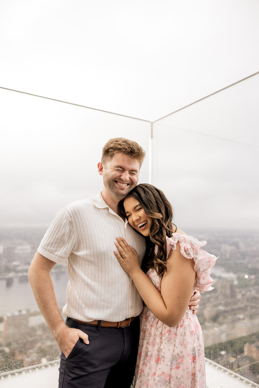 beautiful couple pose on a rooftop with Boston in the background