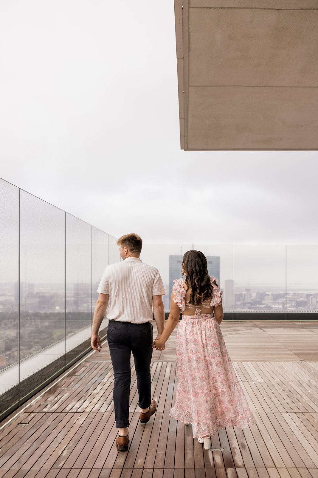 beautiful couple pose on a rooftop with Boston in the background