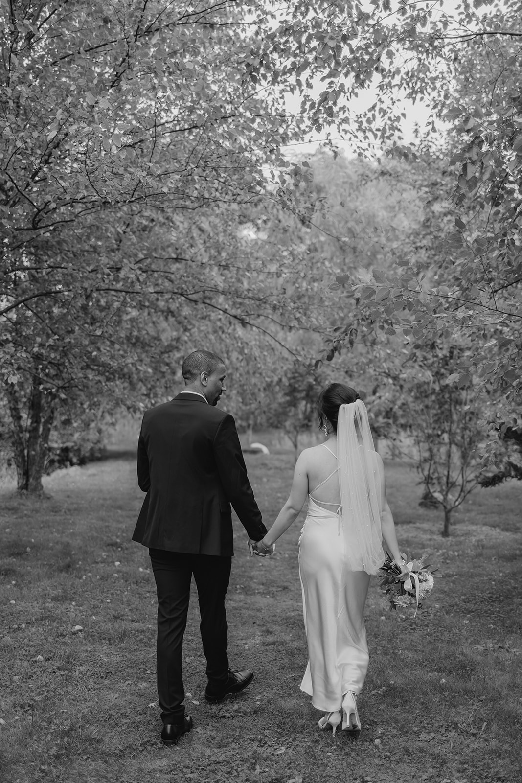 Stunning bride and groom walk in the garden together 