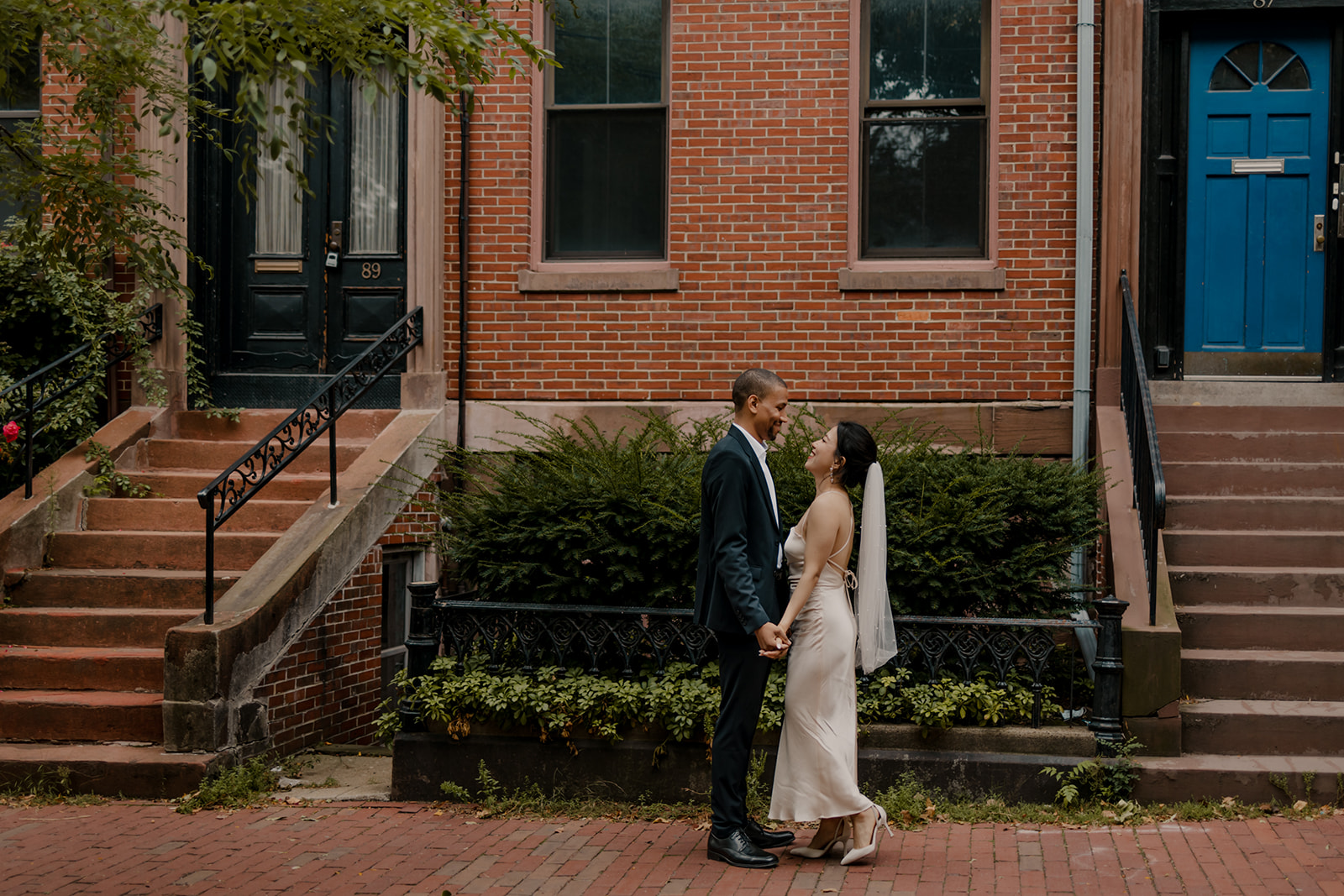 stunning bride and groom pose together against a classic brick wall background