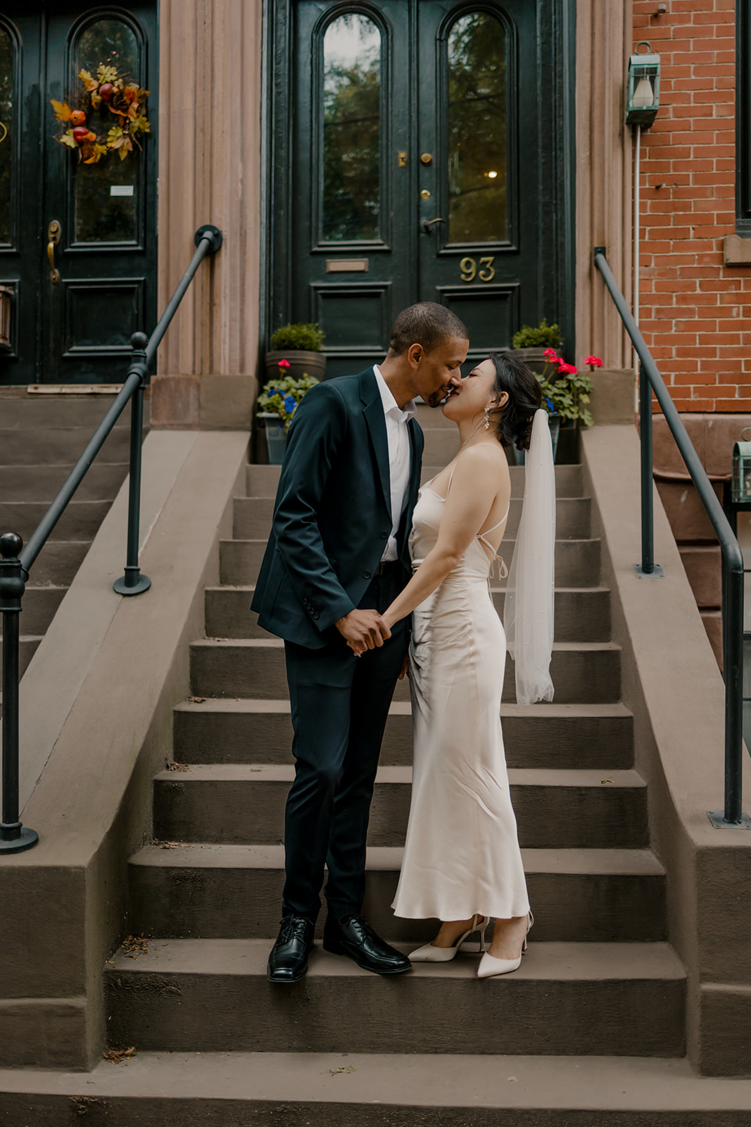 couple share a kiss on the steps of a classic Boston townhouse