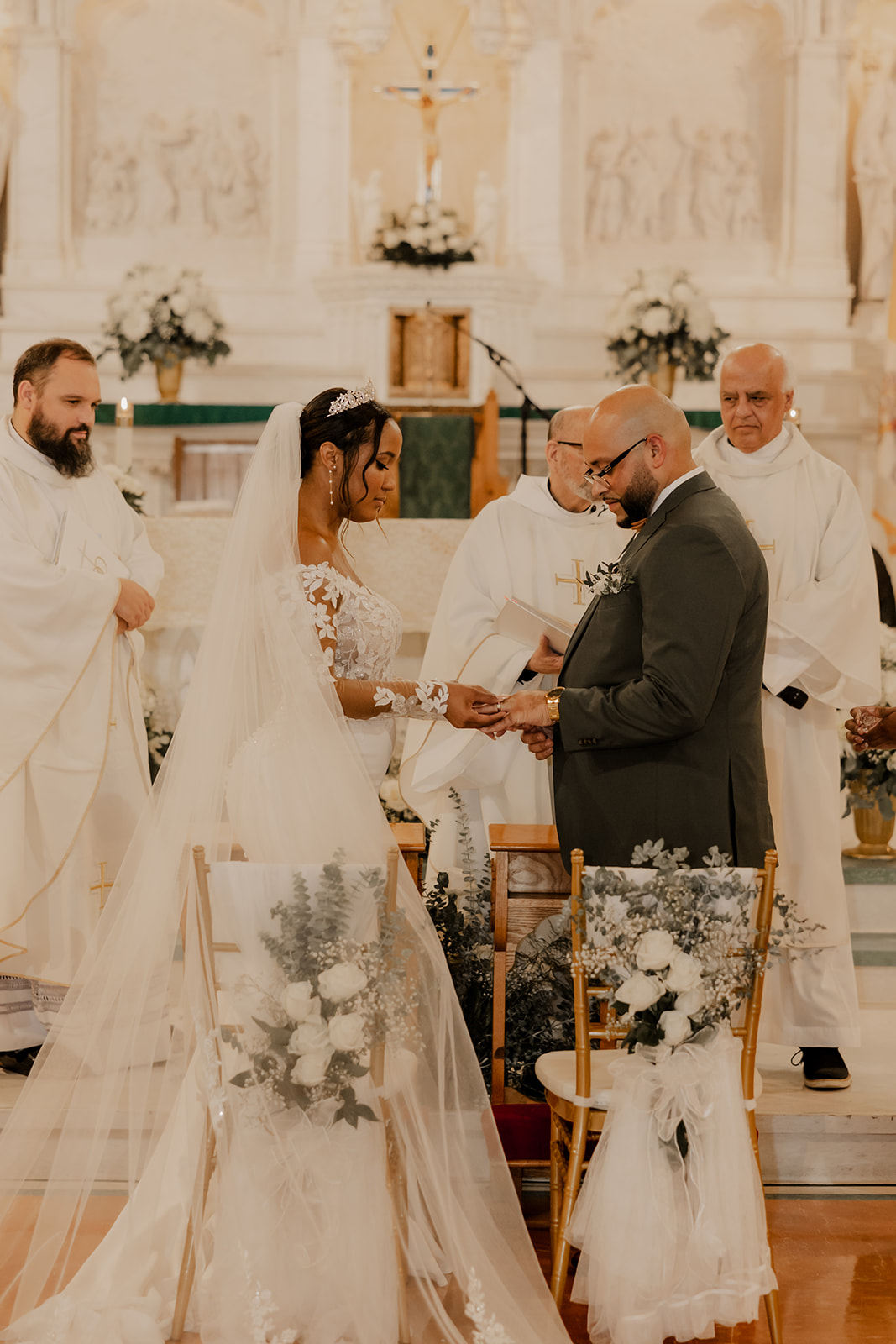 bride and groom stand together holding hands during their classy Boston church wedding ceremony