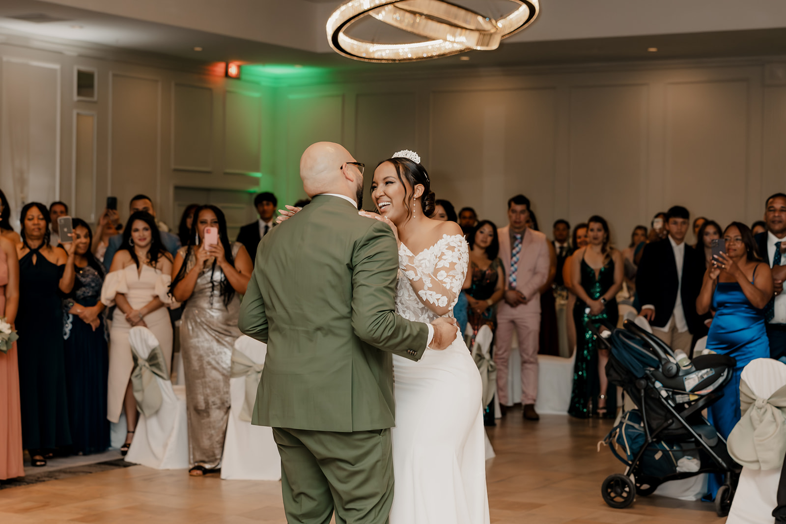 bride and groom share their first dance together as their guests look on