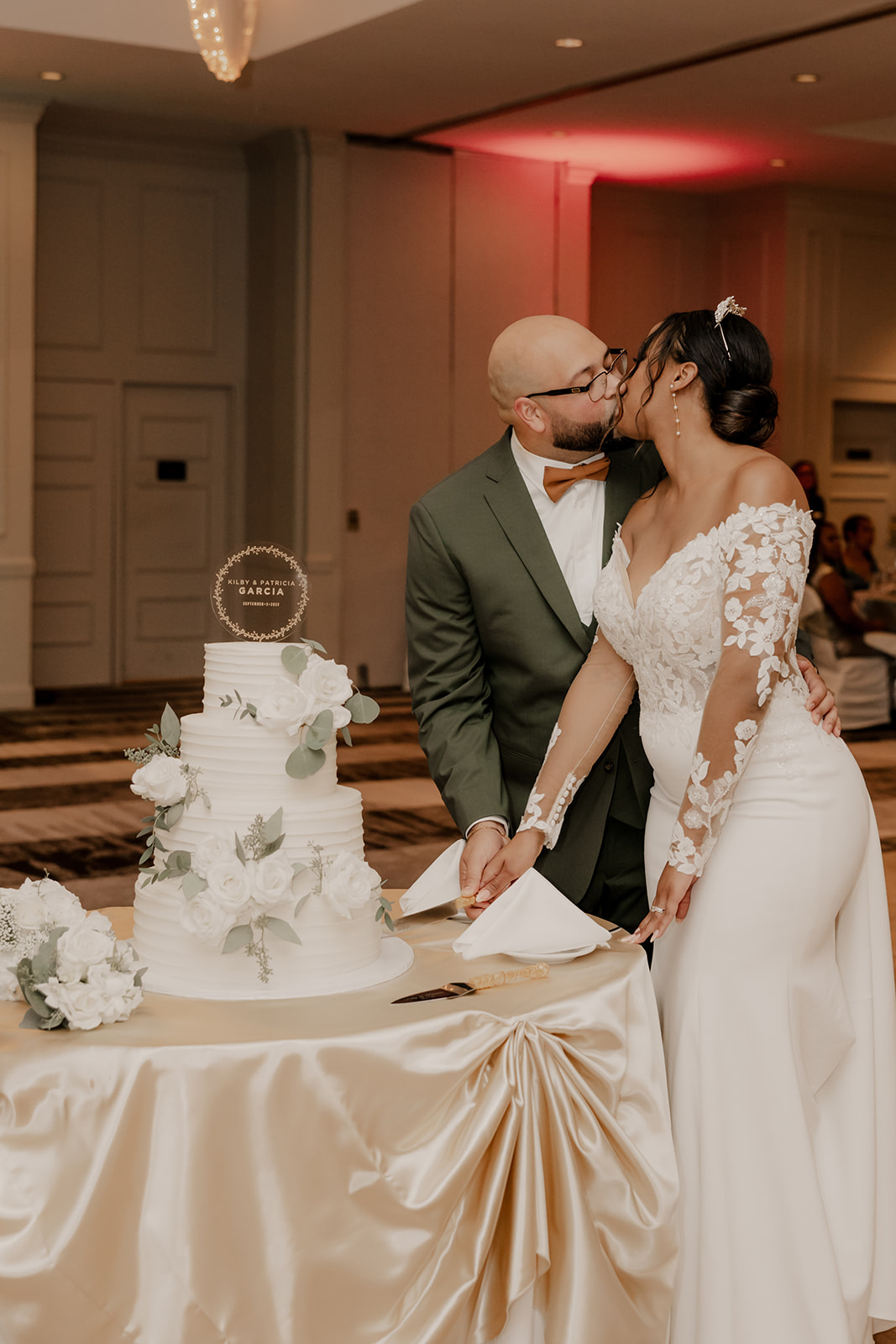 bride and groom share a kiss as they cut their wedding cake