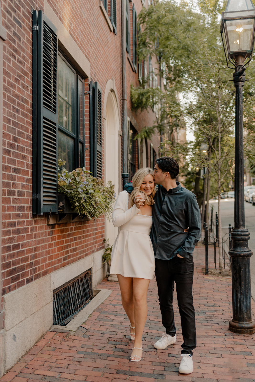 couple walk the streets of Boston taking candid style engagement photos 