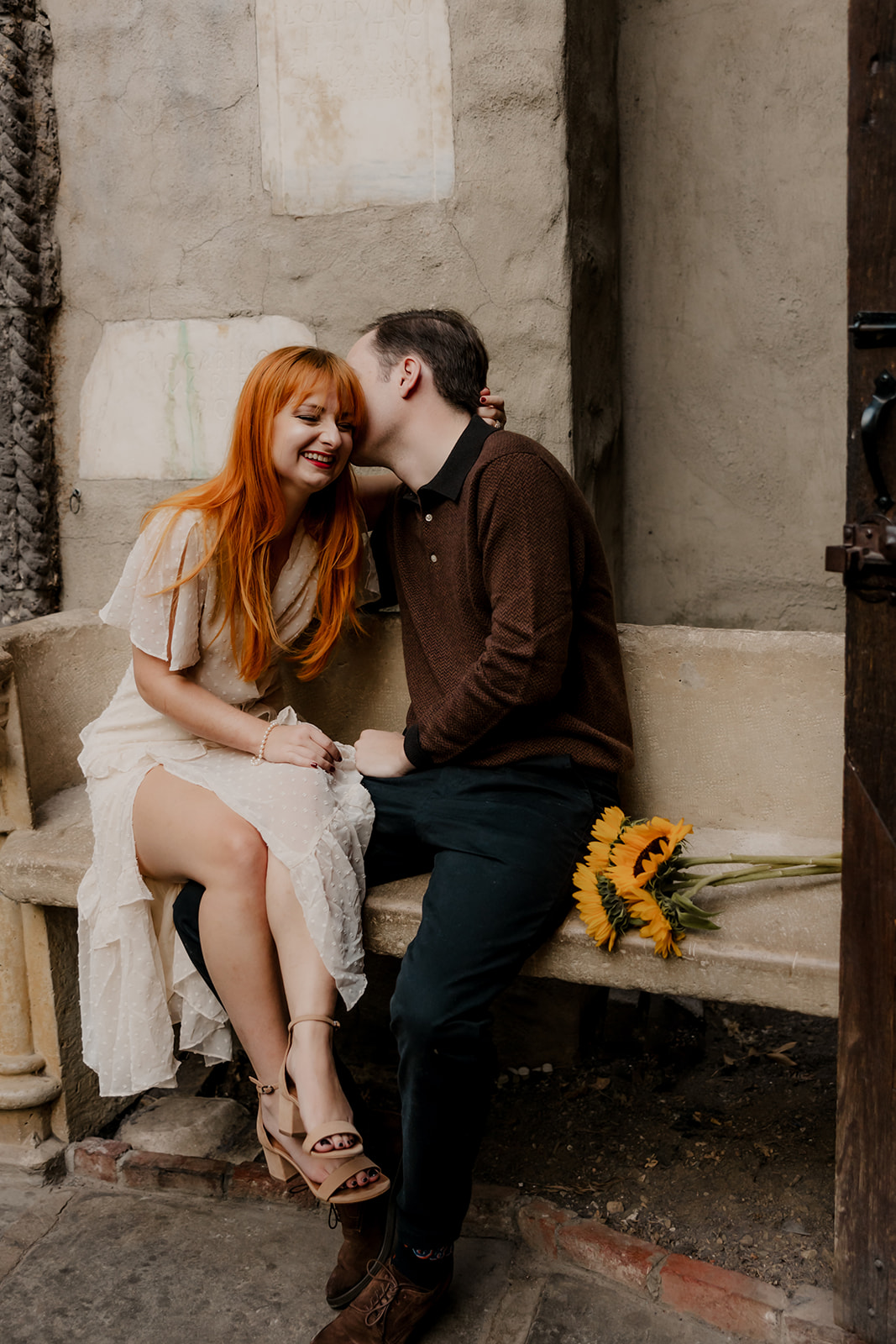 beautiful couple pose on the bench outside the Hammond castle during their Massachusetts engagement photoshoot