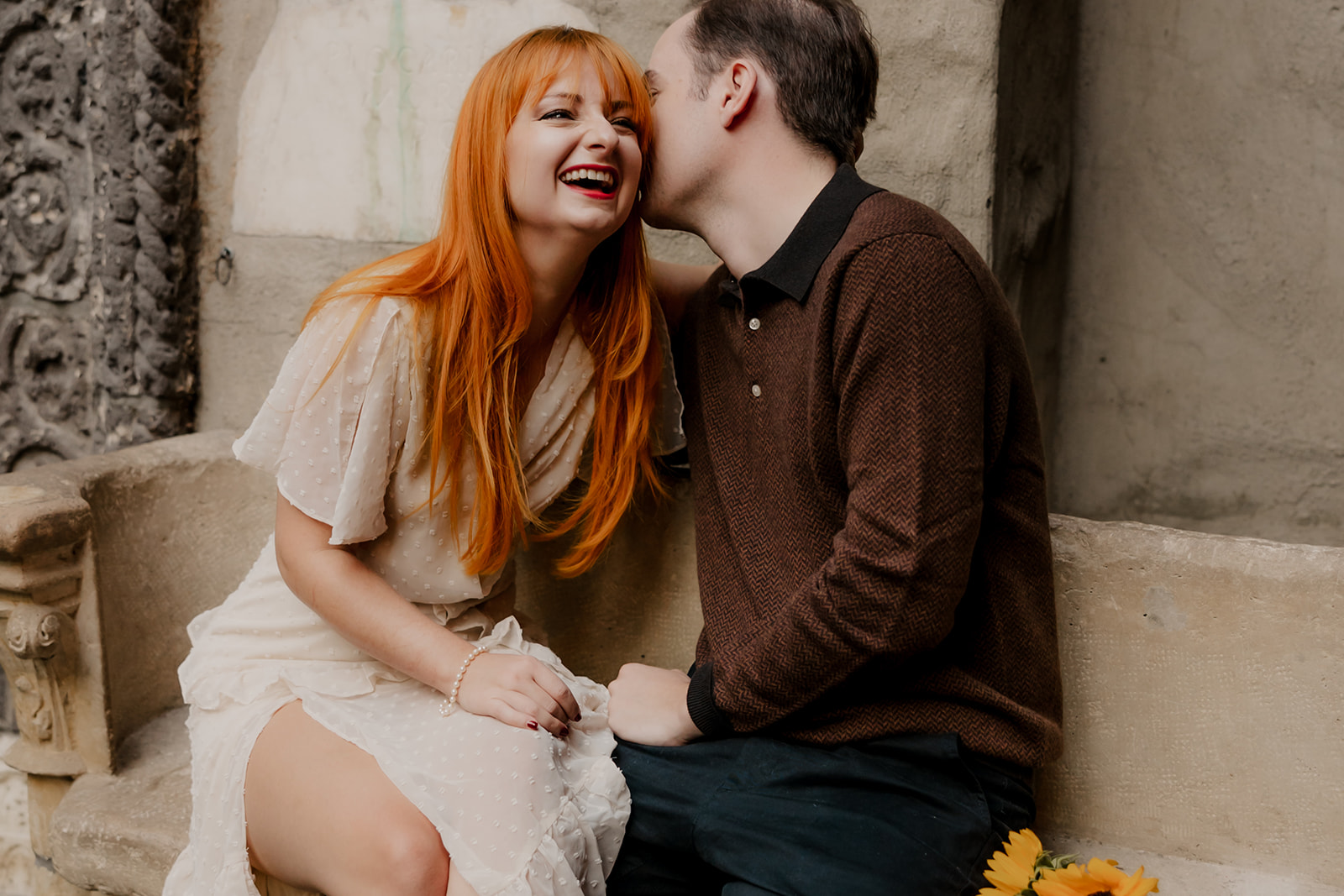 beautiful couple pose on the bench outside the Hammond castle during their Massachusetts engagement photoshoot