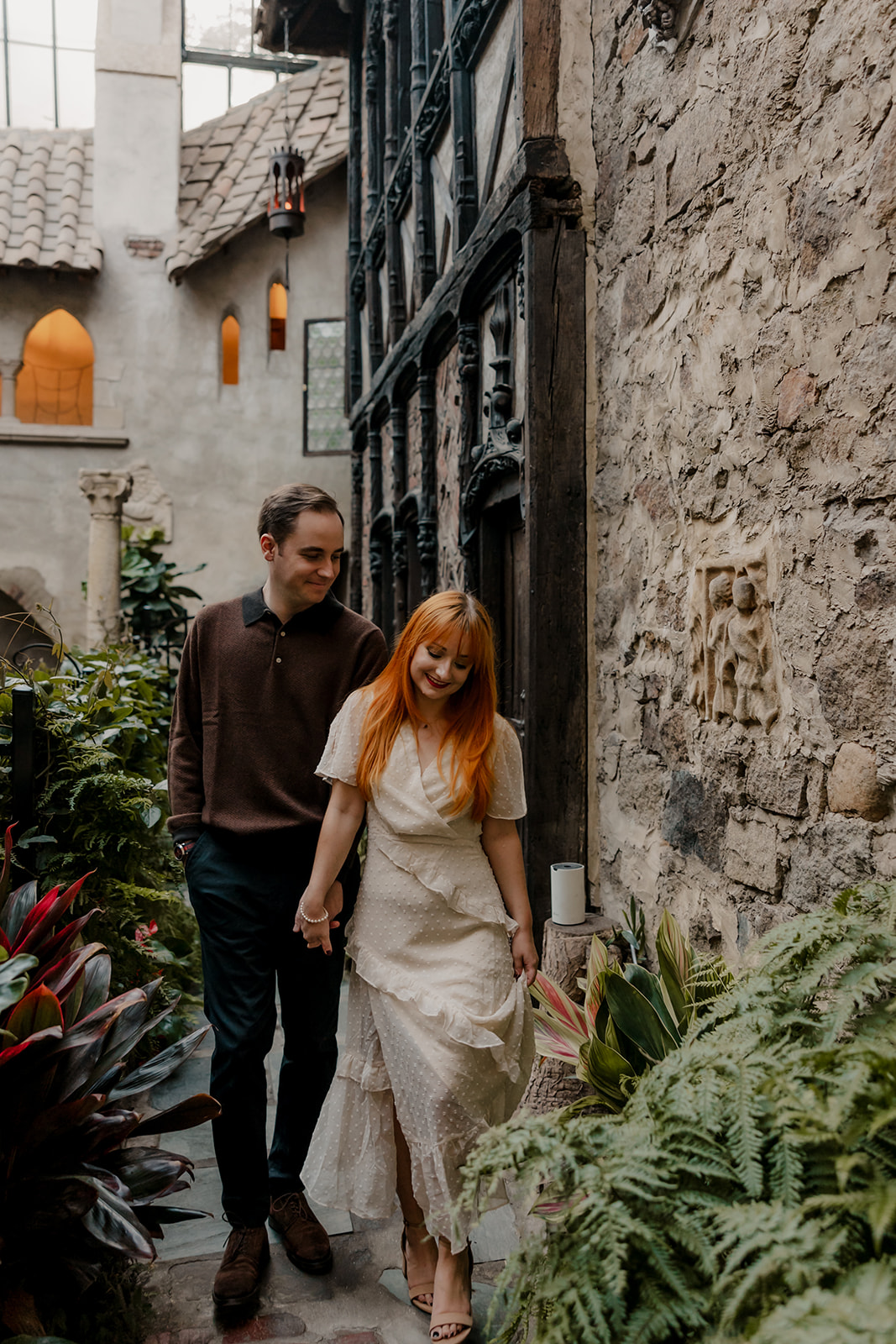 couple walk through the castle garden 