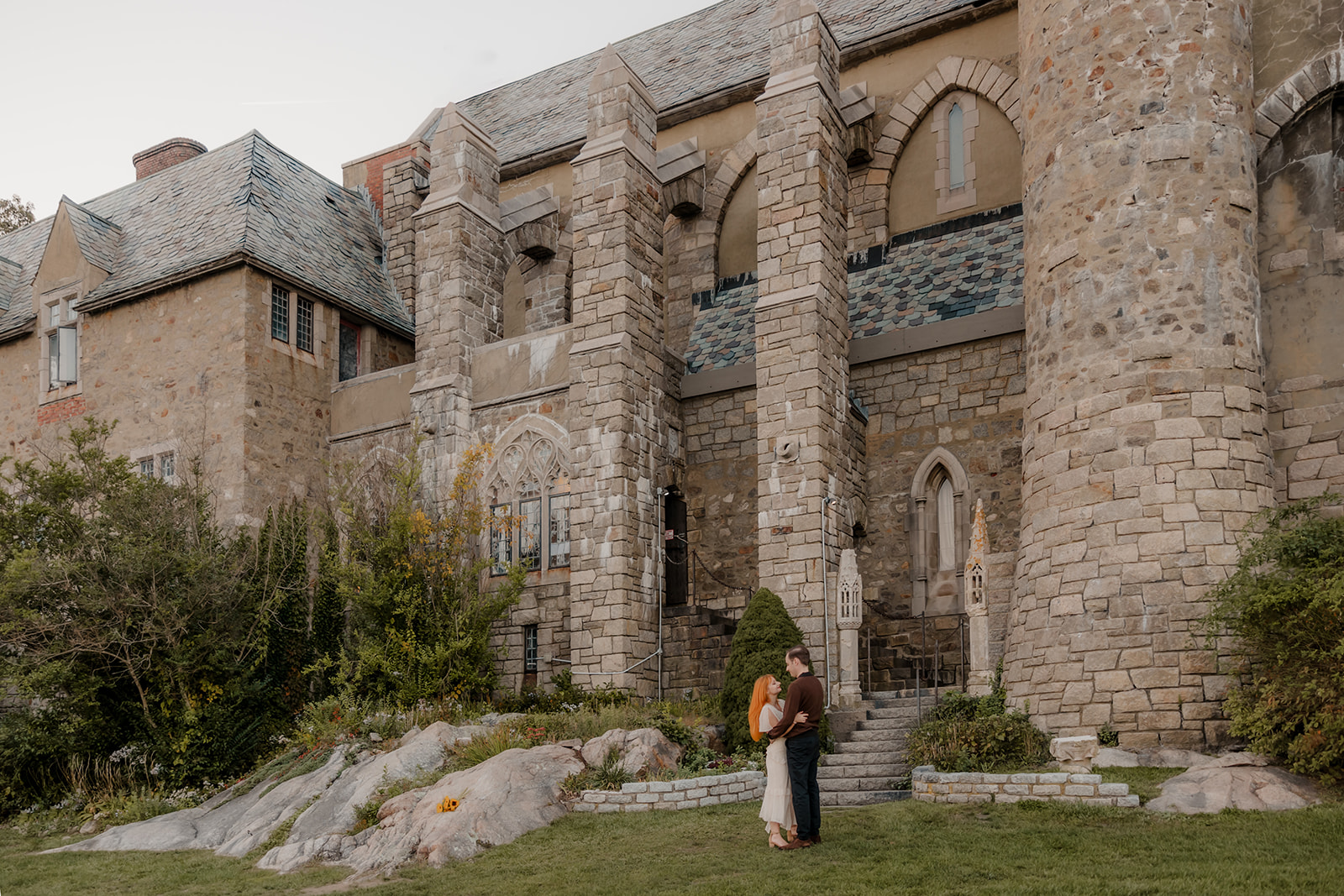 beautiful couple pose outside the Hammond castle during their Massachusetts engagement photoshoot   