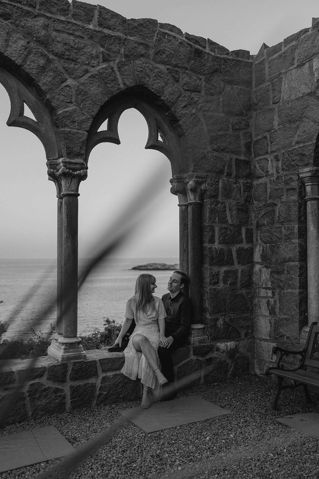 beautiful couple pose inside the Hammond castle overlooking the sea during their Massachusetts engagement photoshoot