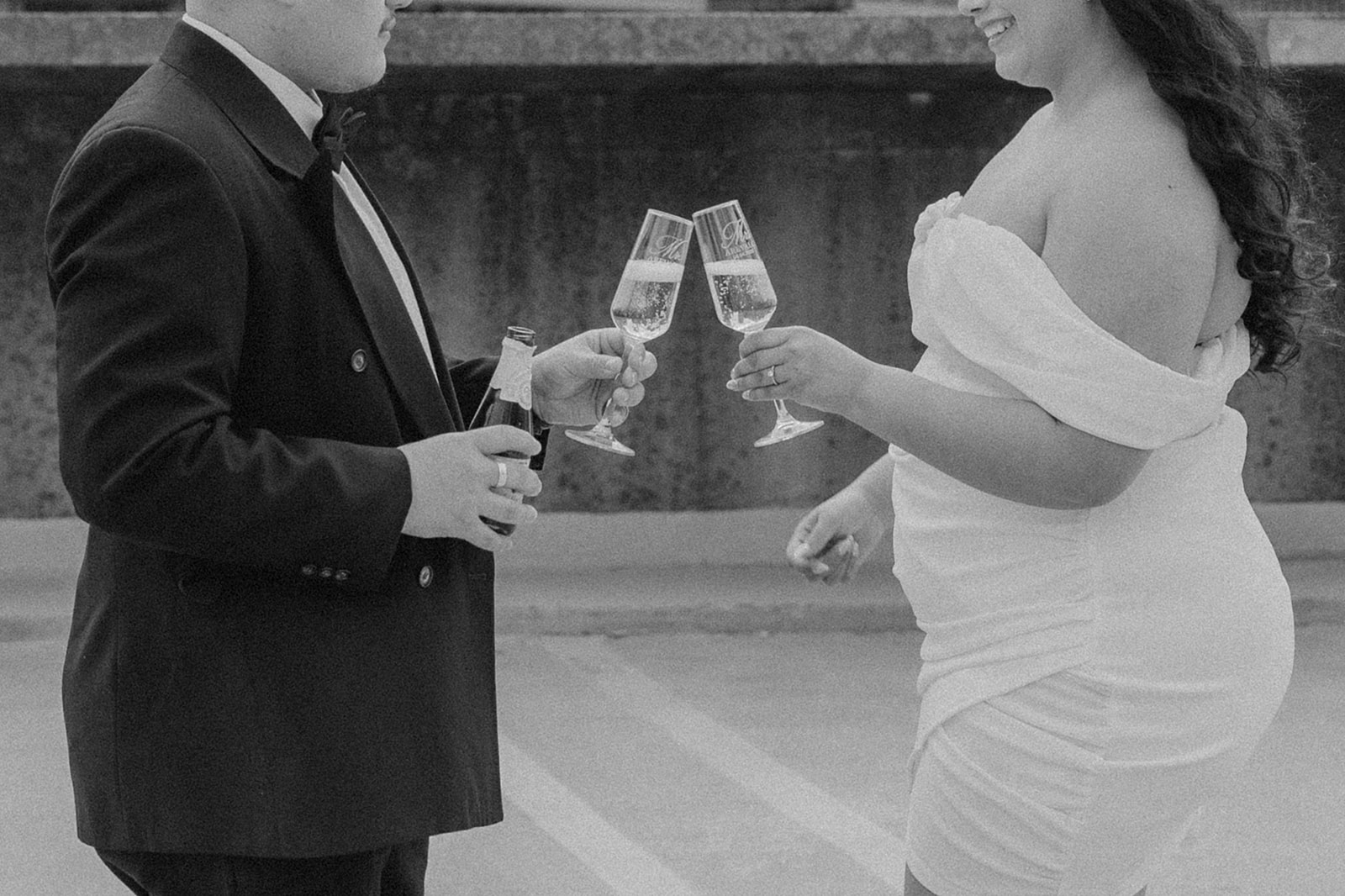 Boston engagement photos share champagne with the downtown skyline in the background