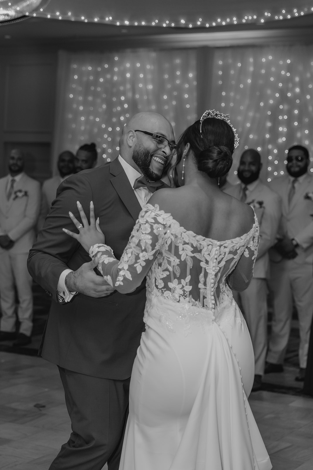 bride and groom share a laugh during their first dance together as their guests look on