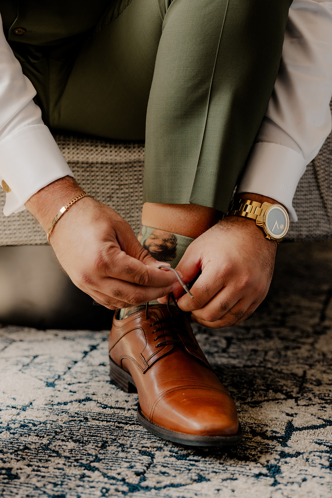 groom ties his shoes as he prepares for his stunning wedding day