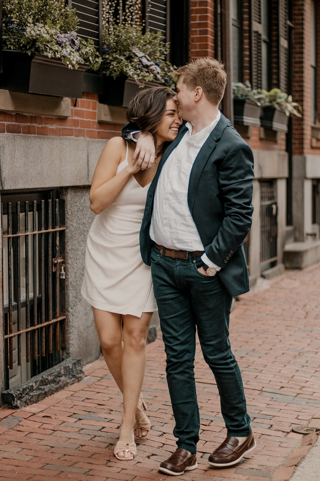 couple walk the streets of Boston taking candid style engagement photos 