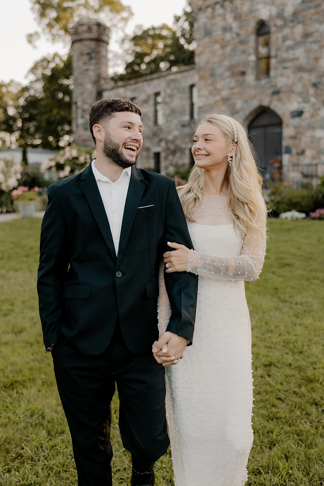 bride and groom pose in front of a castle for their day-after wedding session.