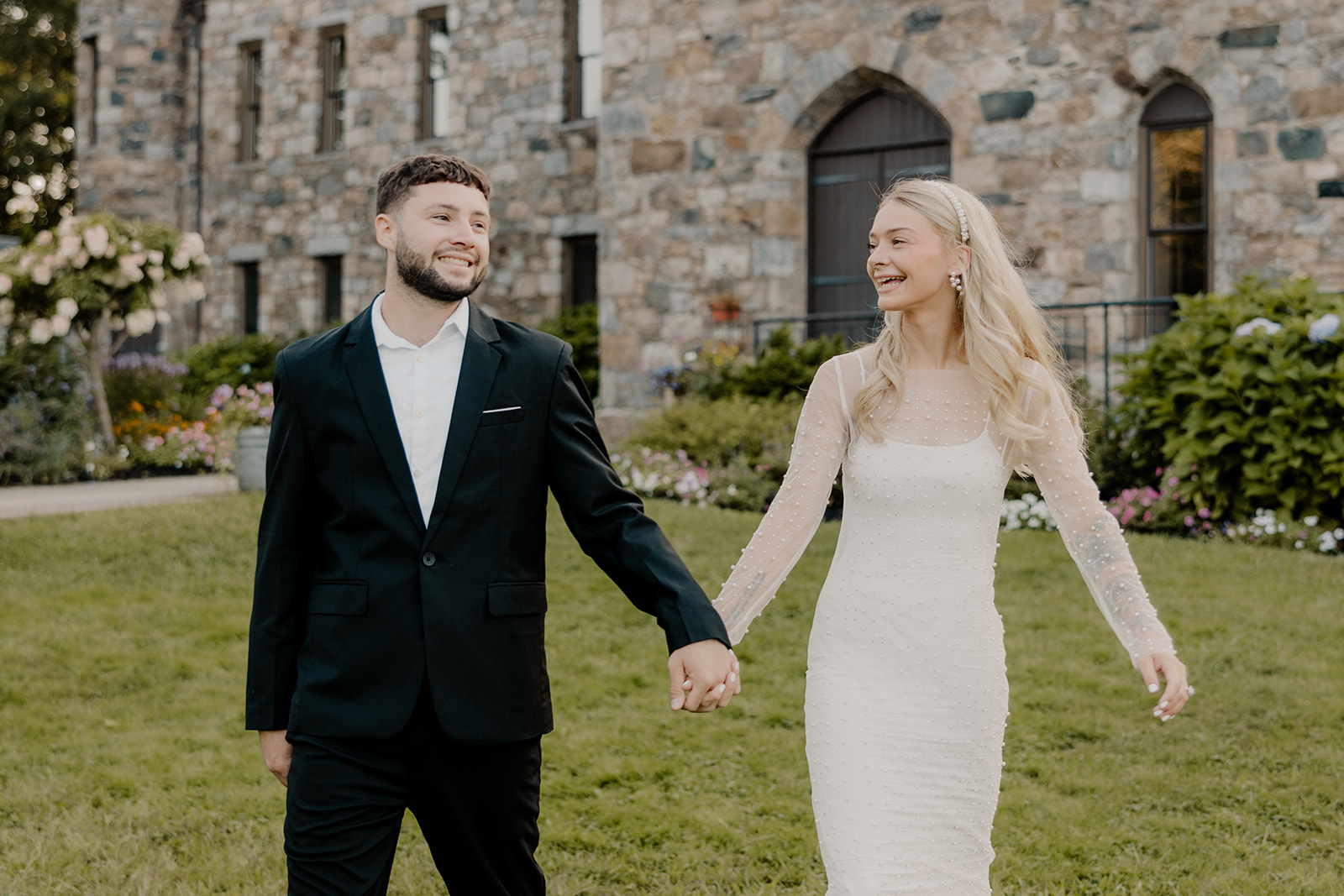 bride and groom walking in front of a castle