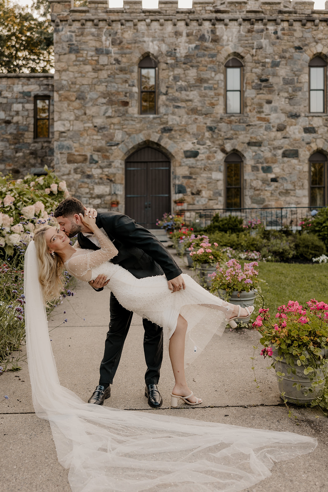 bride and groom pose in front of a castle for their day-after wedding session.