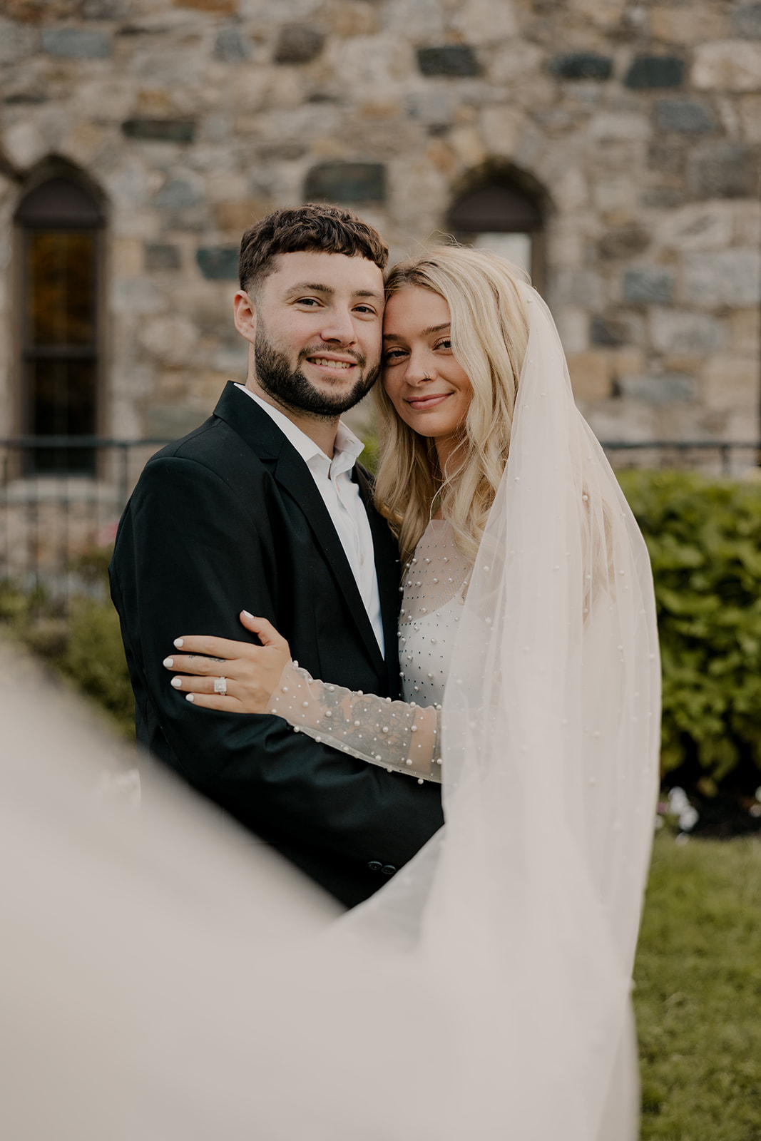 bride and groom pose in front of a castle for their day-after wedding session.