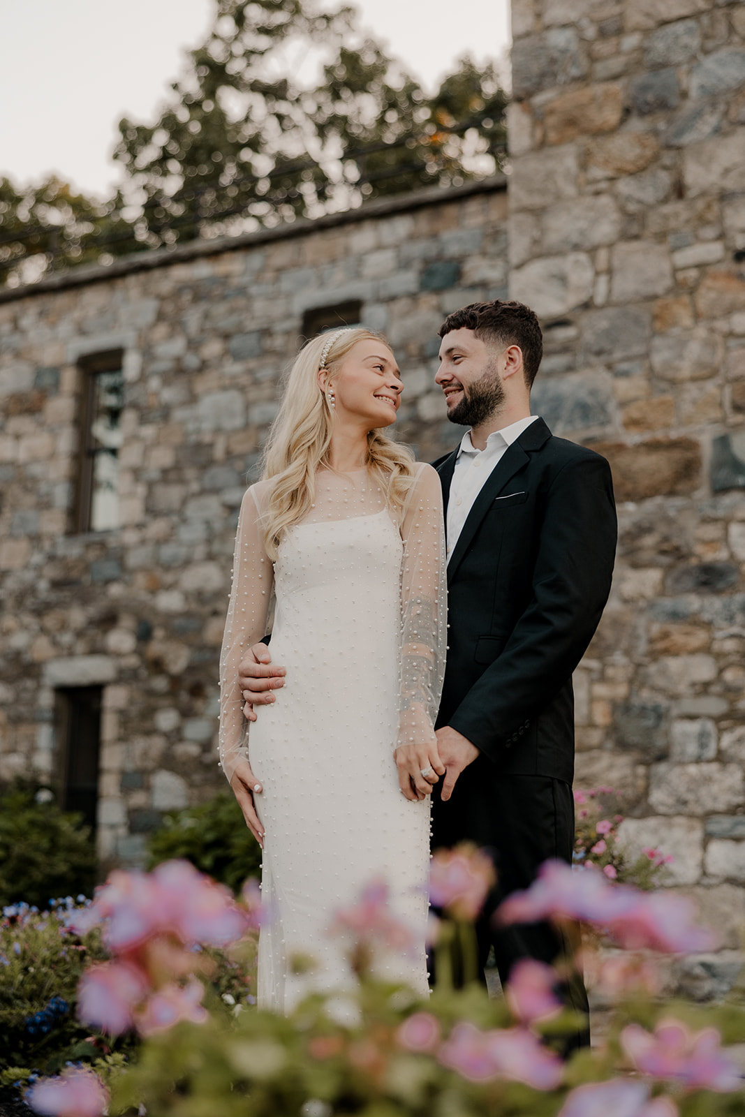 bride and groom pose in front of a castle for their day-after wedding session.