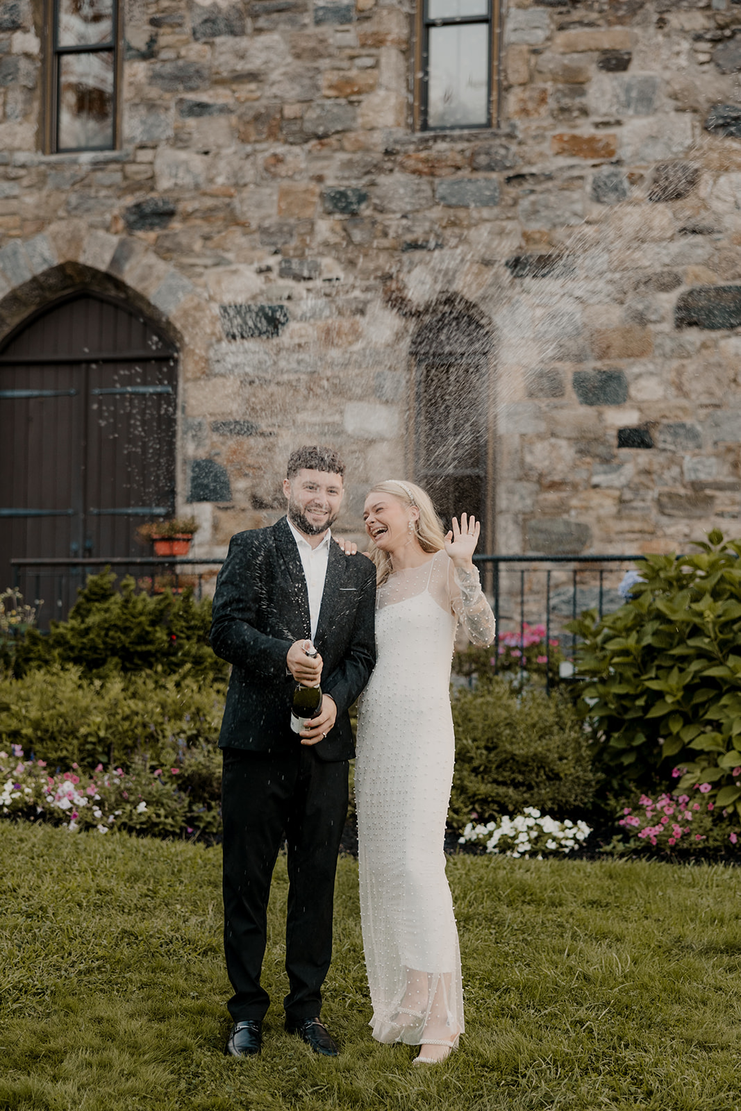 bride and groom pop champagne during their wedding portraits