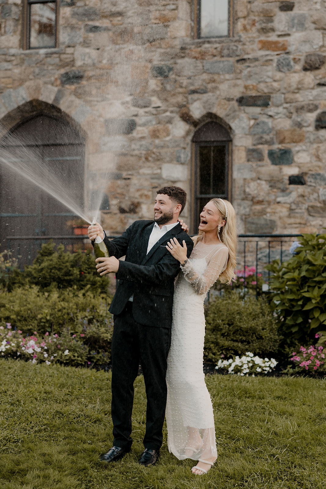 bride and groom pop champagne during their wedding portraits