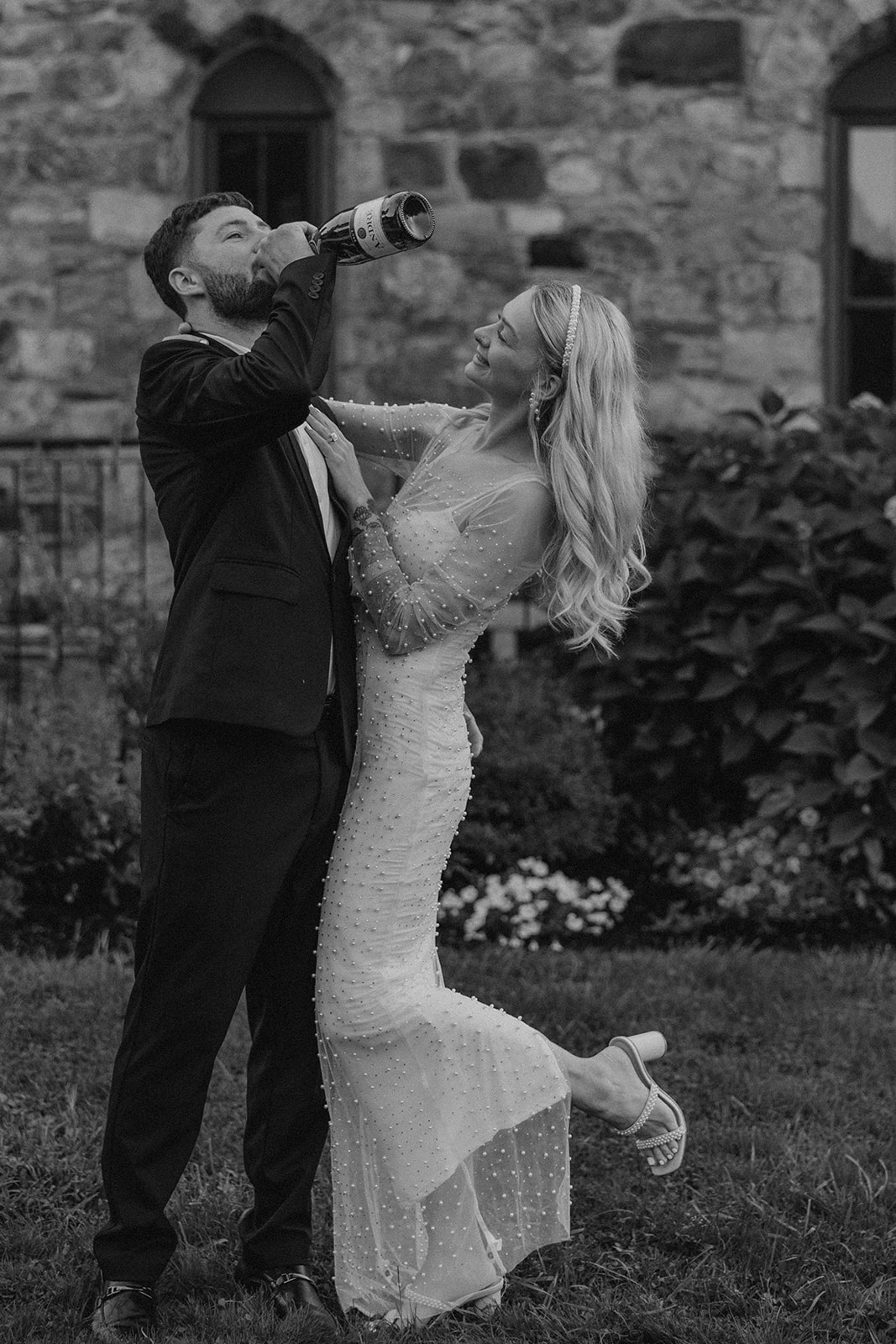 bride and groom pop champagne during their wedding portraits