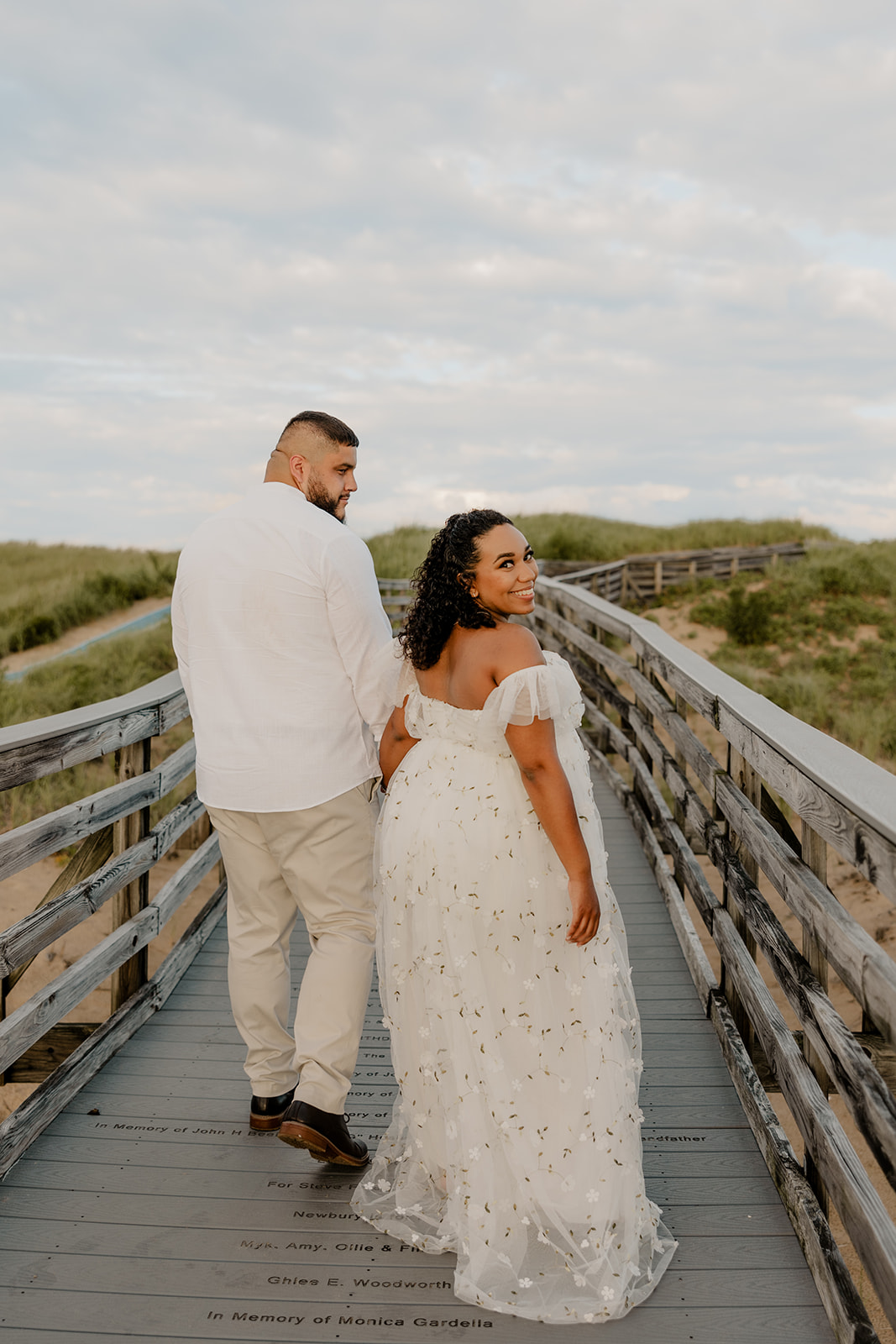 beautiful couple pose for their maternity photoshoot on an East Coast beach