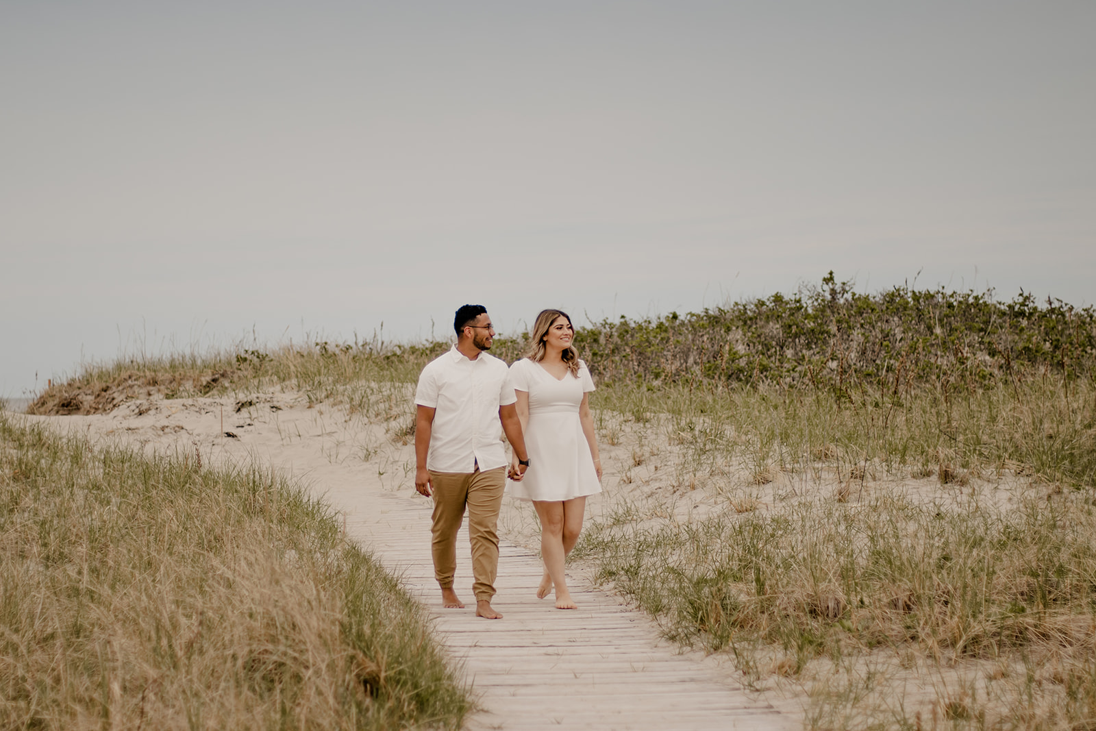 beautiful couple poses on a Boston beach for their dreamy engagement photo shoot