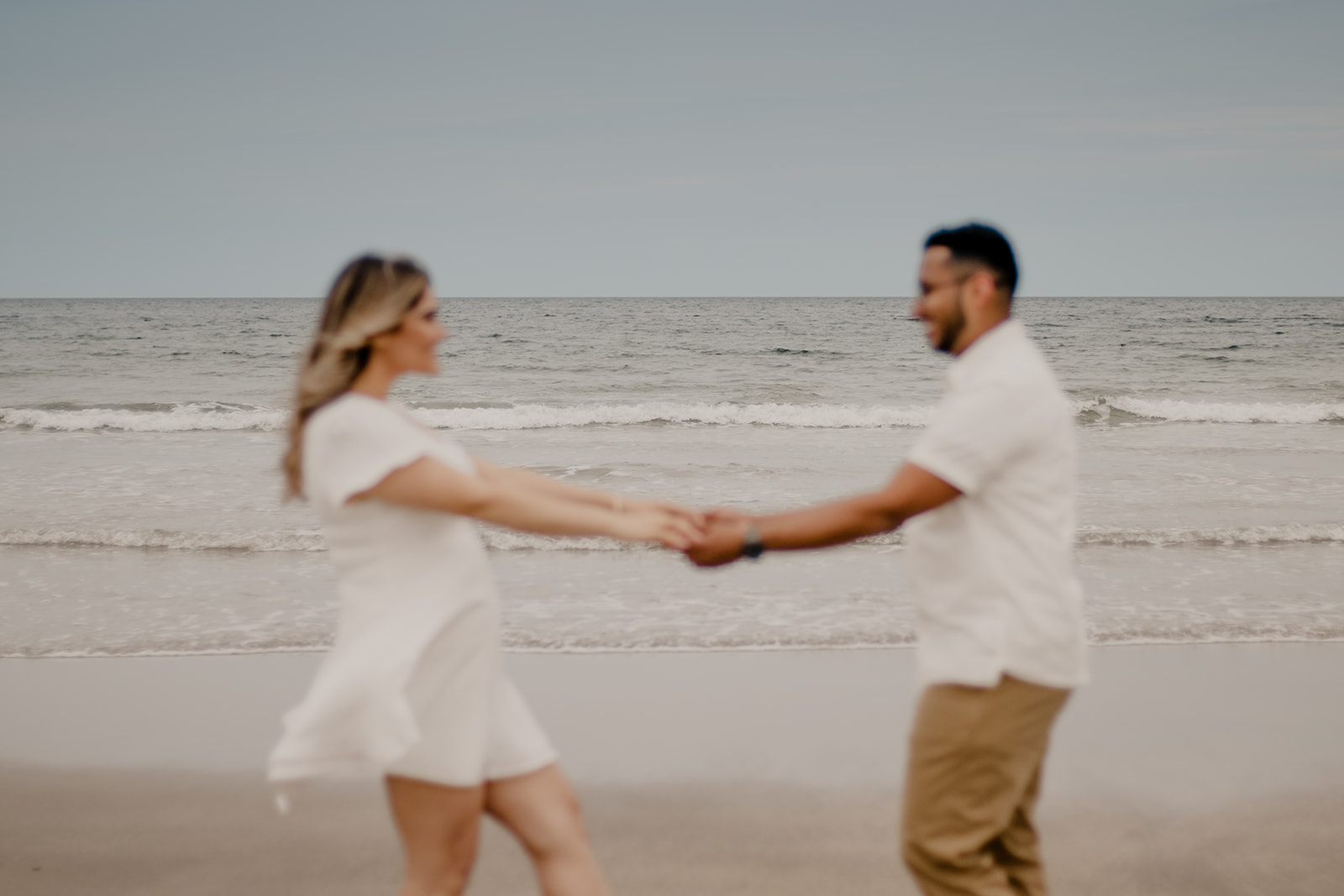 beautiful couple poses on a Boston beach for their dreamy engagement photo shoot