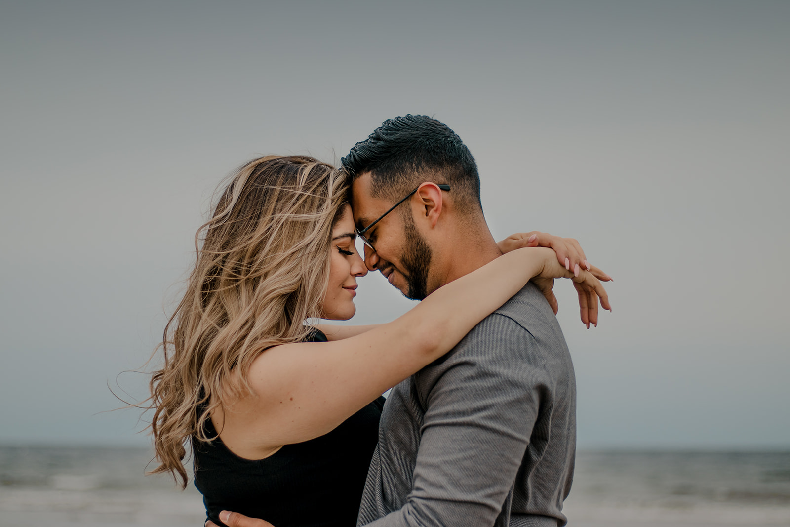 beautiful couple poses on a Boston beach for their dreamy engagement photo shoot