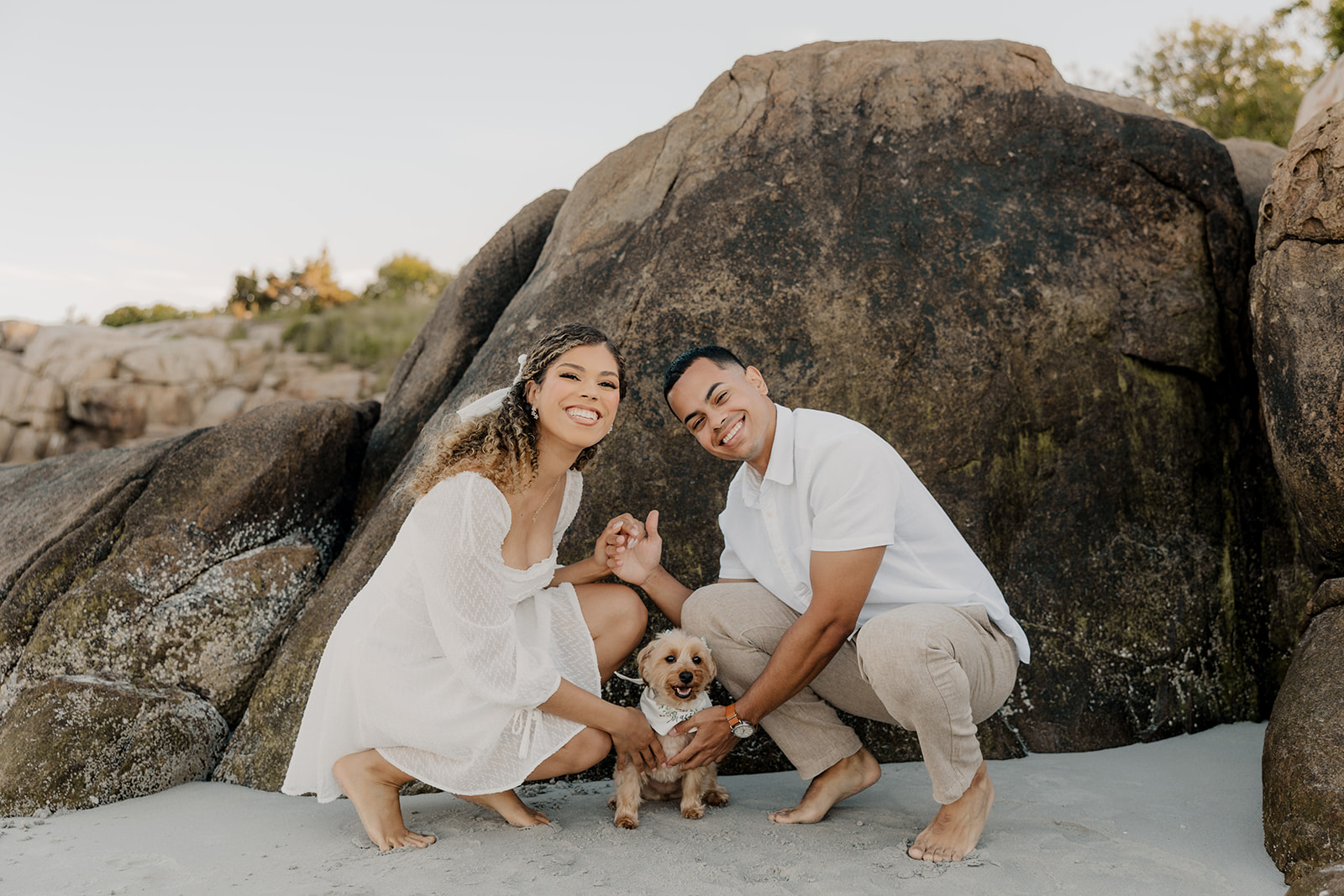 stunning couple pose with their dog during their beach engagement photoshoot