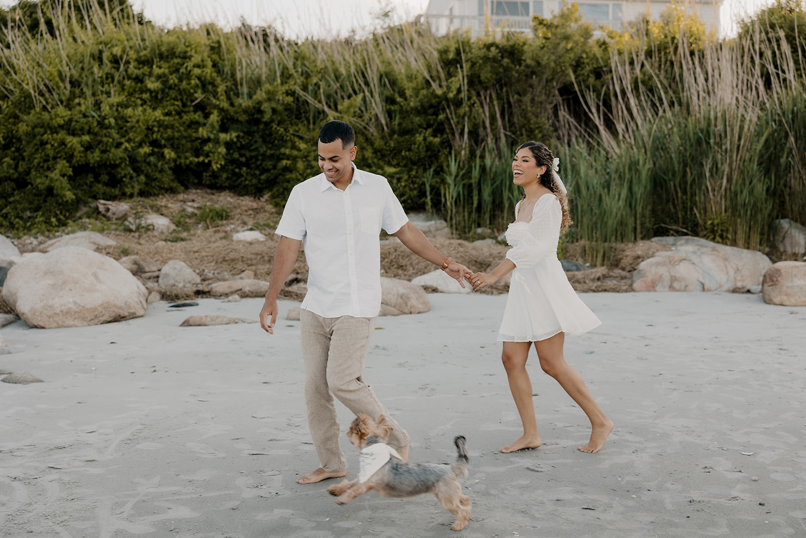 beautiful couple walk on the beach together during their New England beach engagement photoshoot