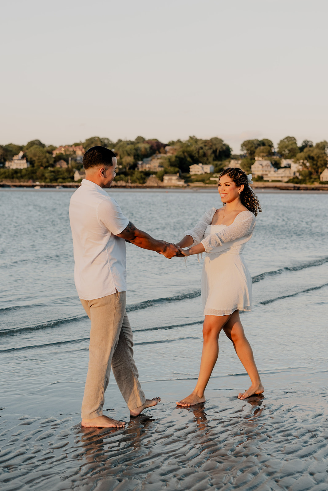 beautiful couple pose on the beach together during their New England beach engagement photoshoot