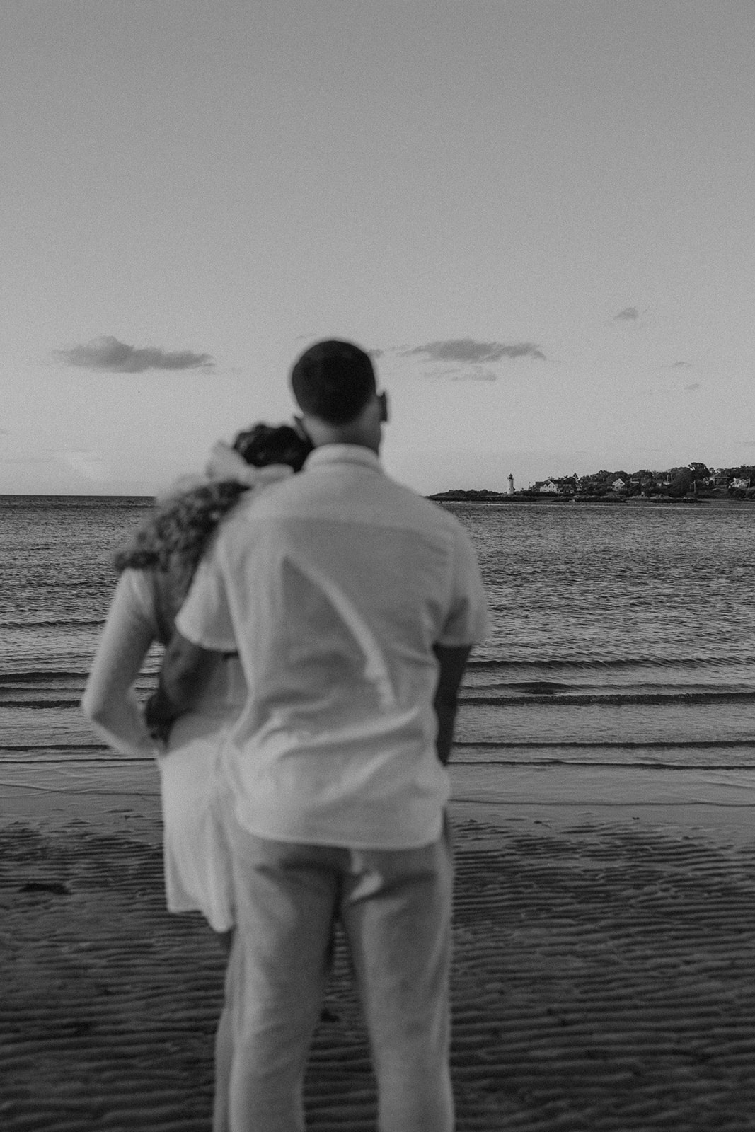 beautiful couple share a romantic pose on a beach during their New England engagement photos