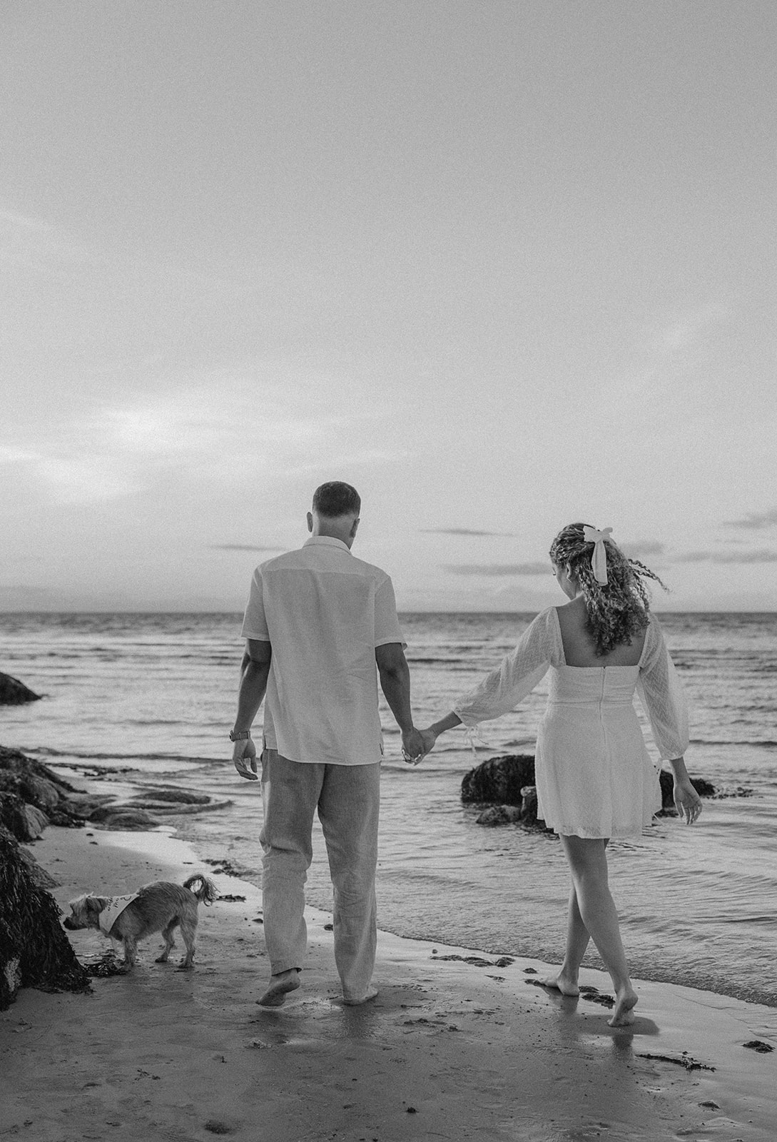 beautiful couple pose on the beach together during their New England beach engagement photoshoot