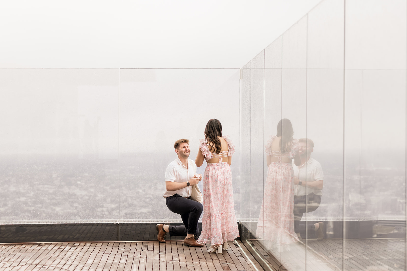 beautiful couple pose together during their surprise proposal at The View in Boston