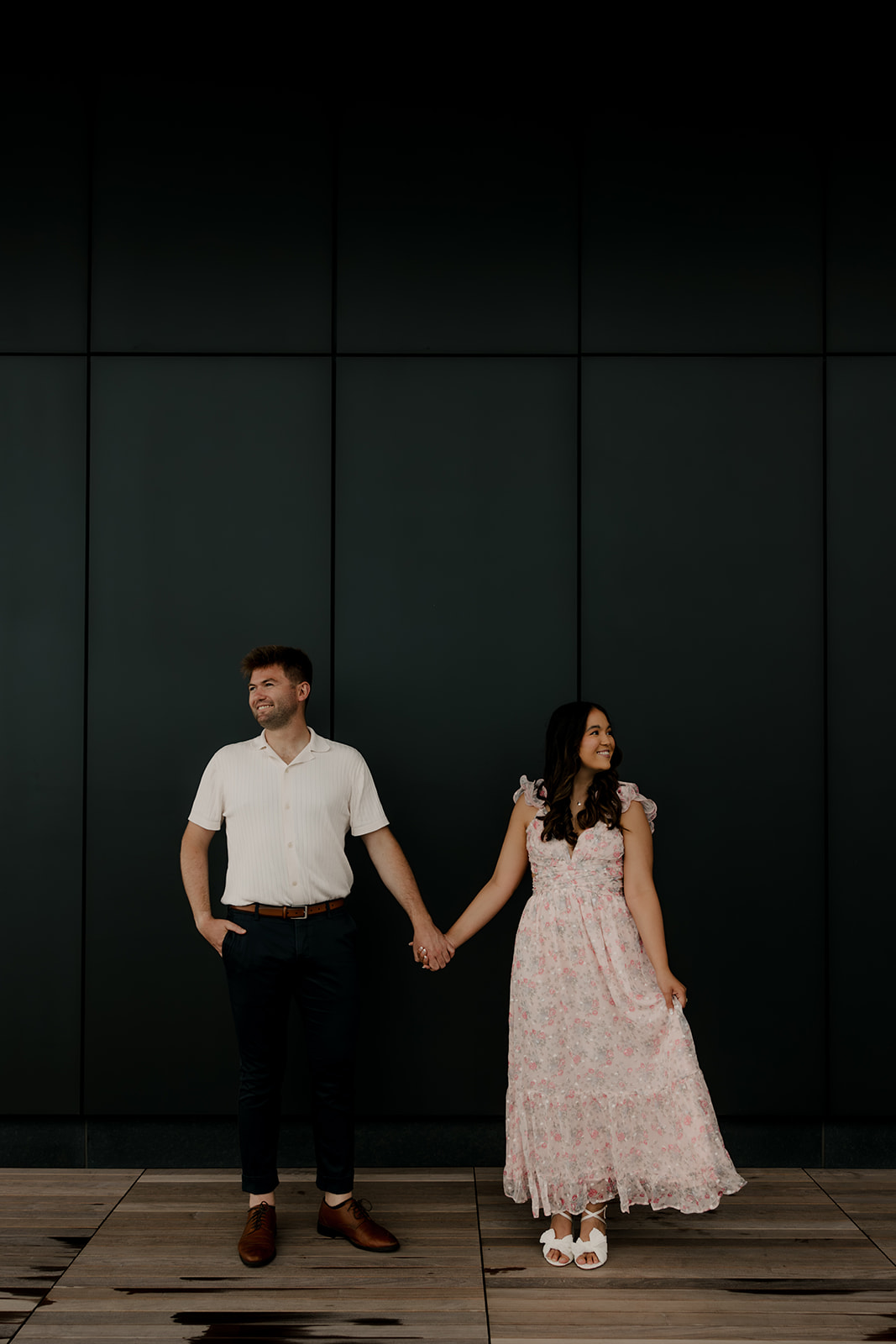 beautiful couple share a moment with a black wall in the background