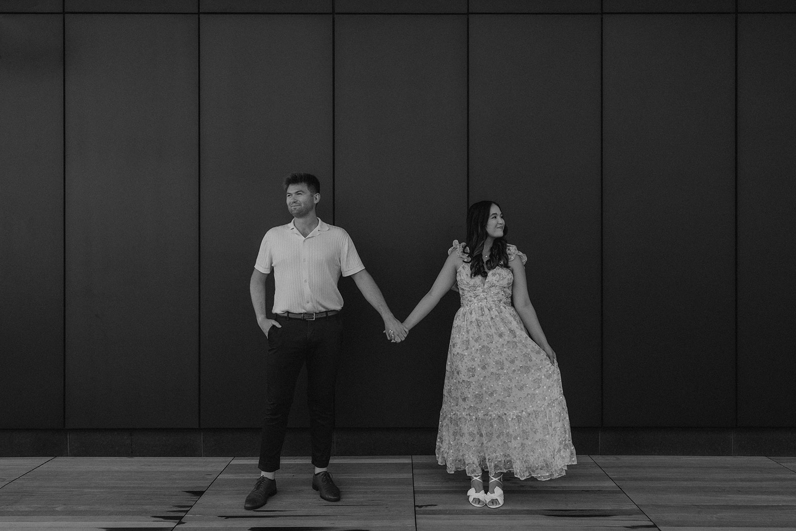 beautiful couple share a moment with a black wall in the background