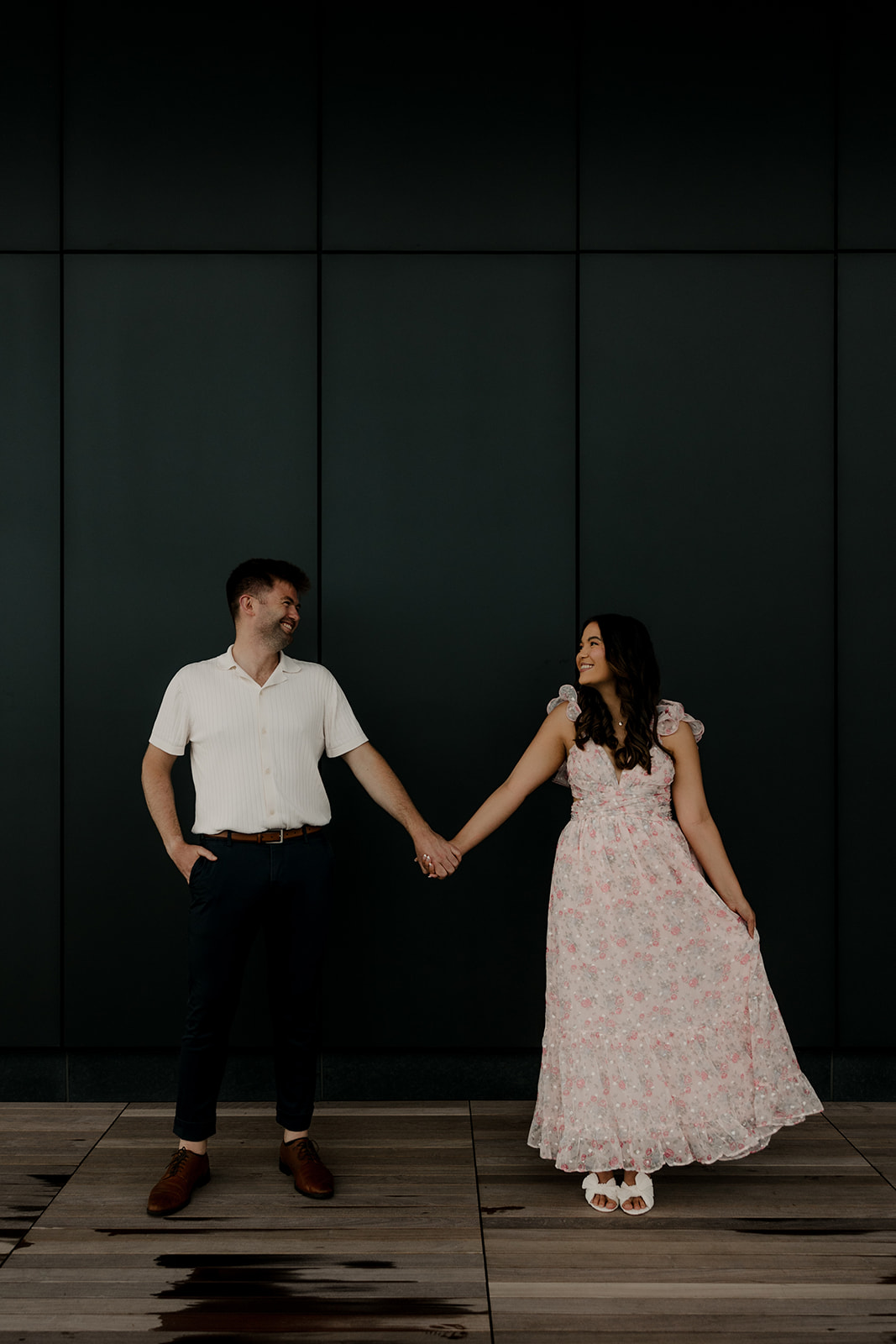 beautiful couple share a moment with a black wall in the background