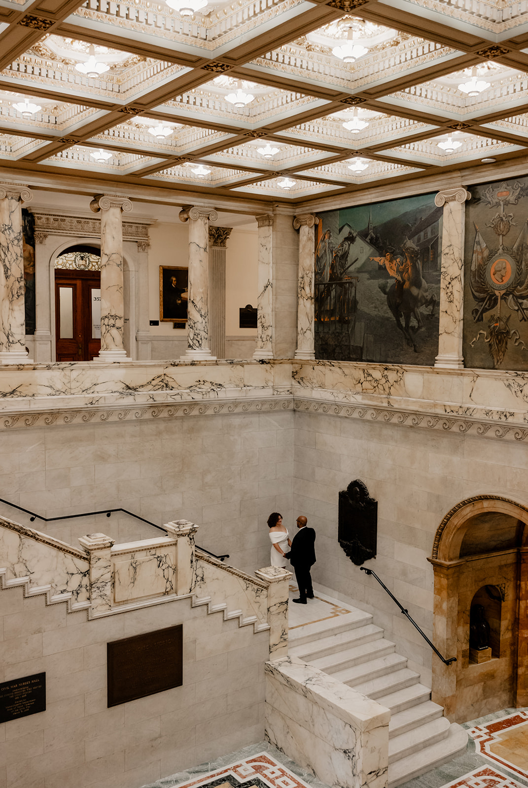 bride and groom share a moment on the grand state house stair case