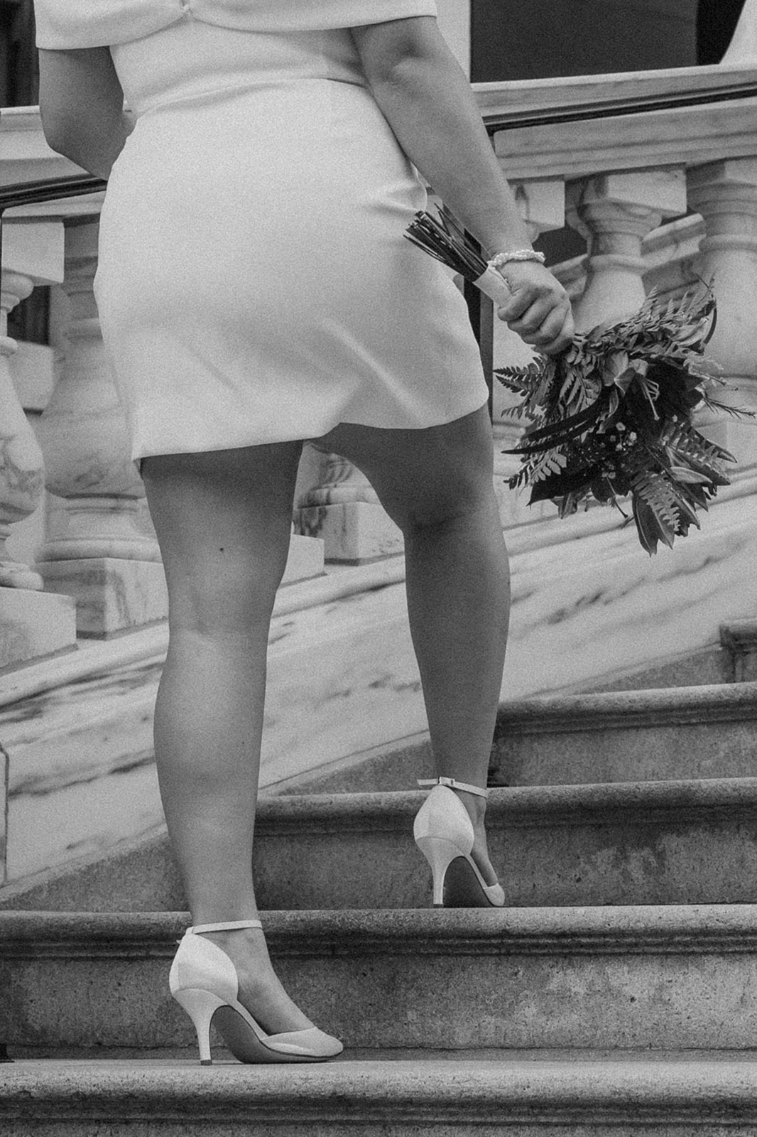 beautiful bride and groom stop for a picture on the stairs during their state house elopement