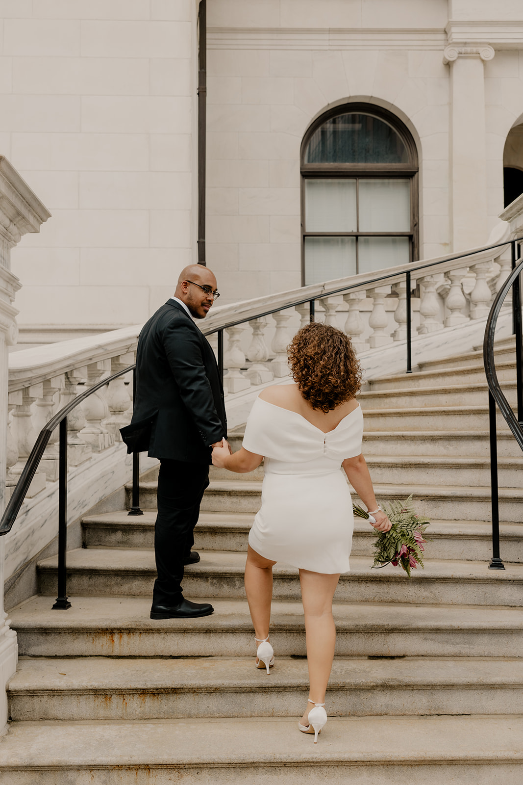 beautiful bride and groom stop for a picture on the stairs