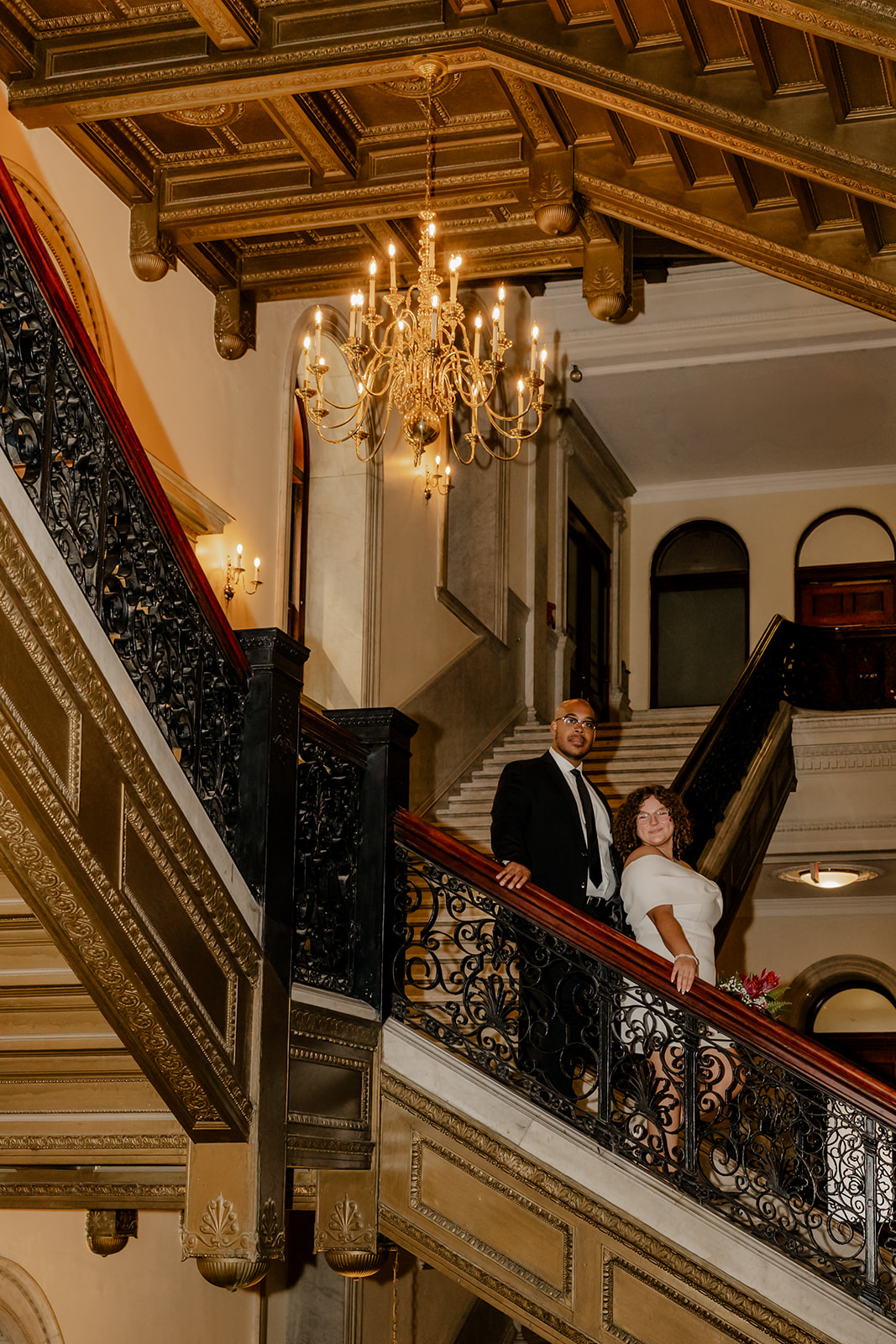 beautiful bride and groom stop for a picture on the stairs