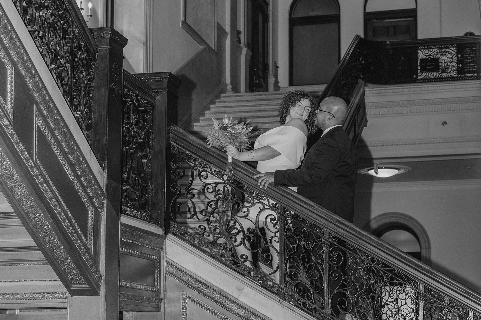 beautiful bride and groom stop for a picture on the stairs