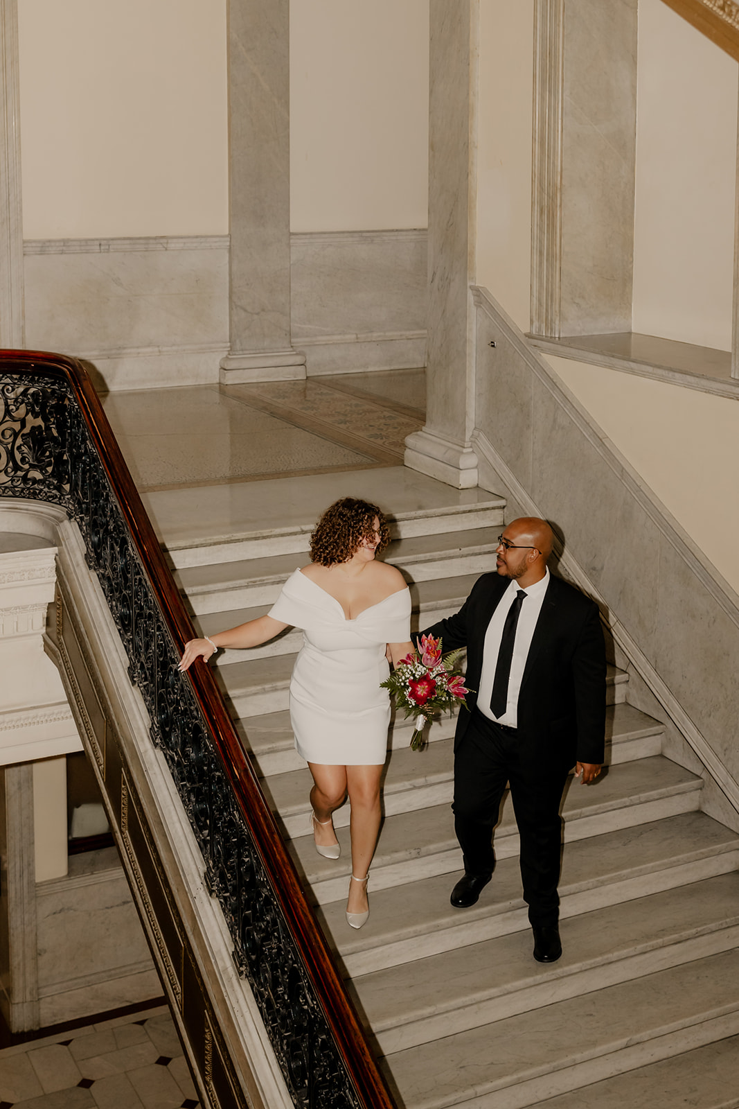 beautiful bride and groom stop for a picture on the stairs