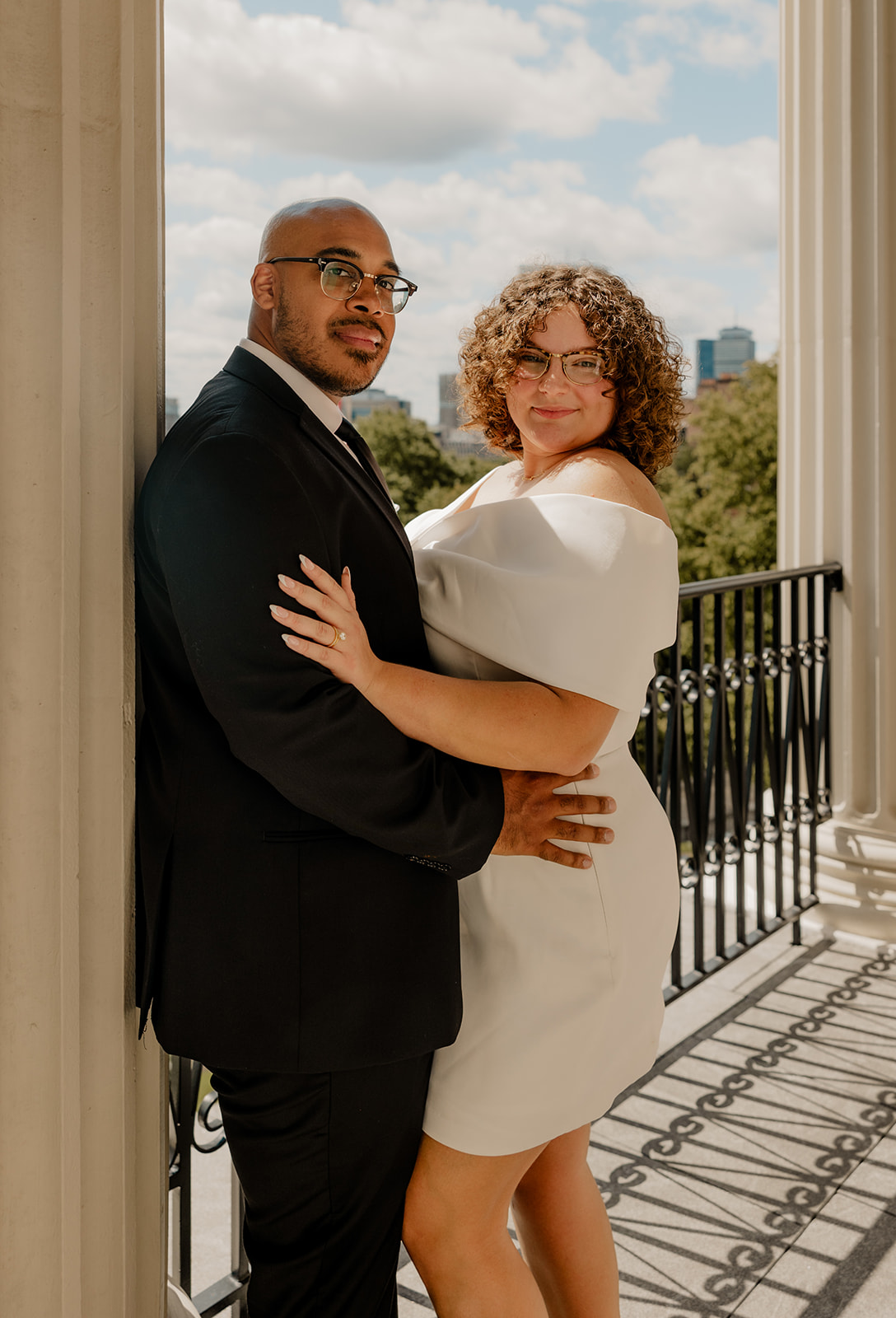 stunning bride and groom pose together on the state house balcony