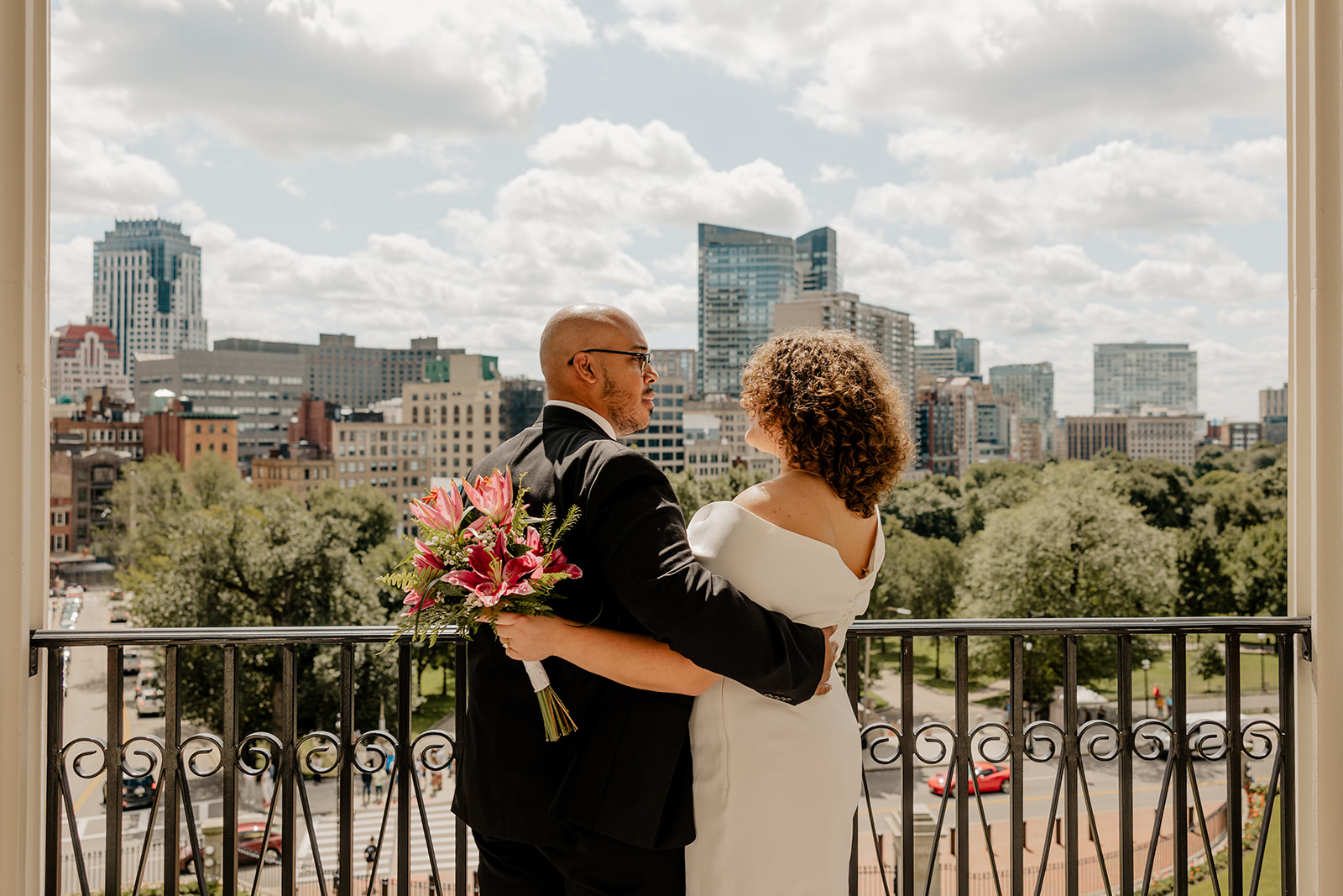 stunning bride and groom pose together on the state house balcony