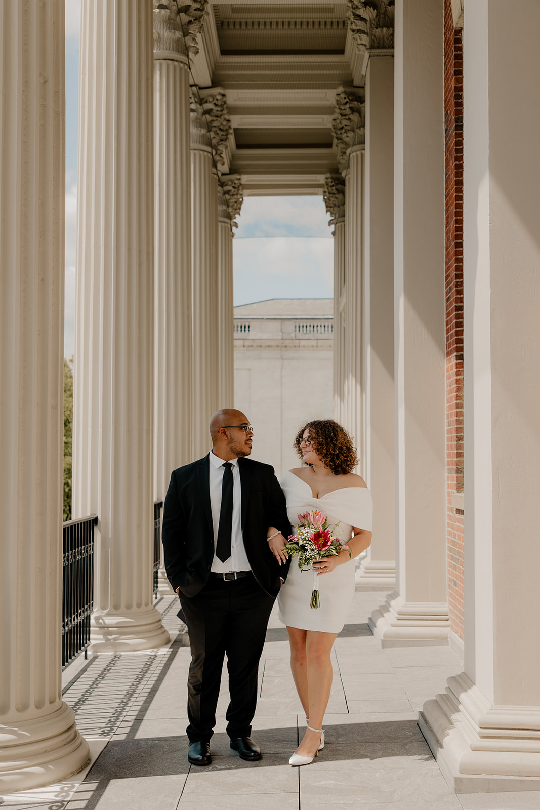 stunning bride and groom pose together on the state house balcony