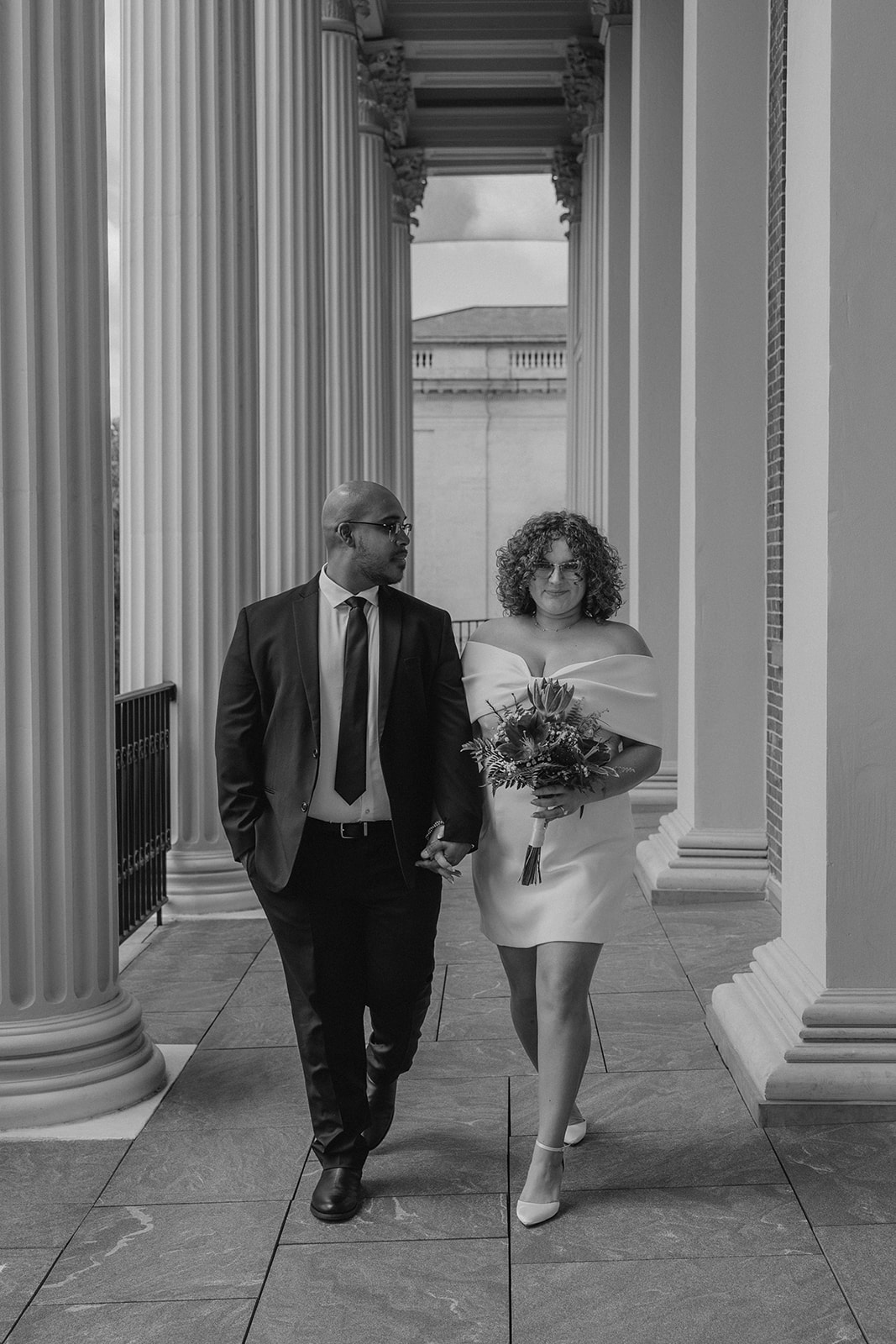 stunning bride and groom pose together on the state house balcony