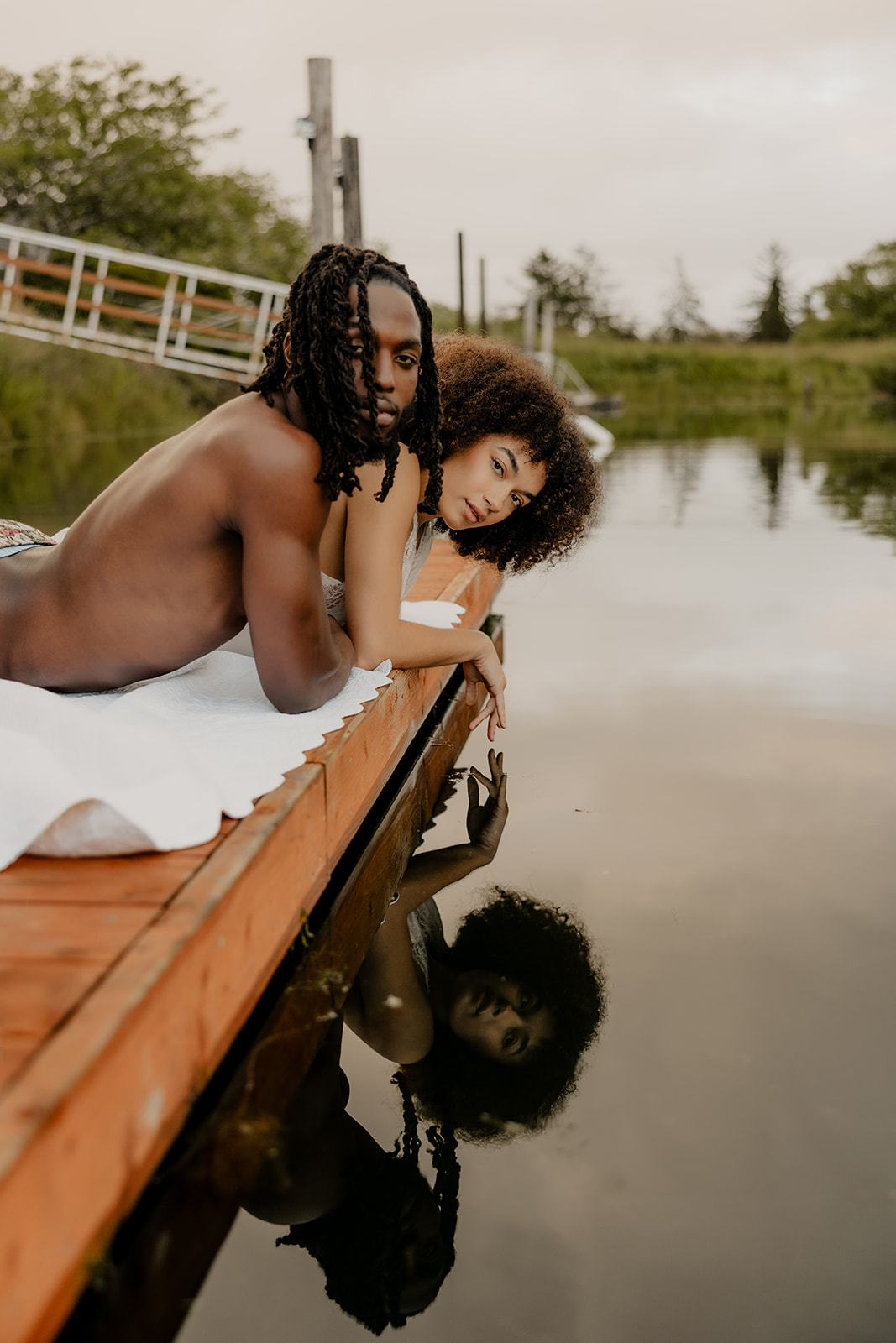 beautiful couple pose together on a dock